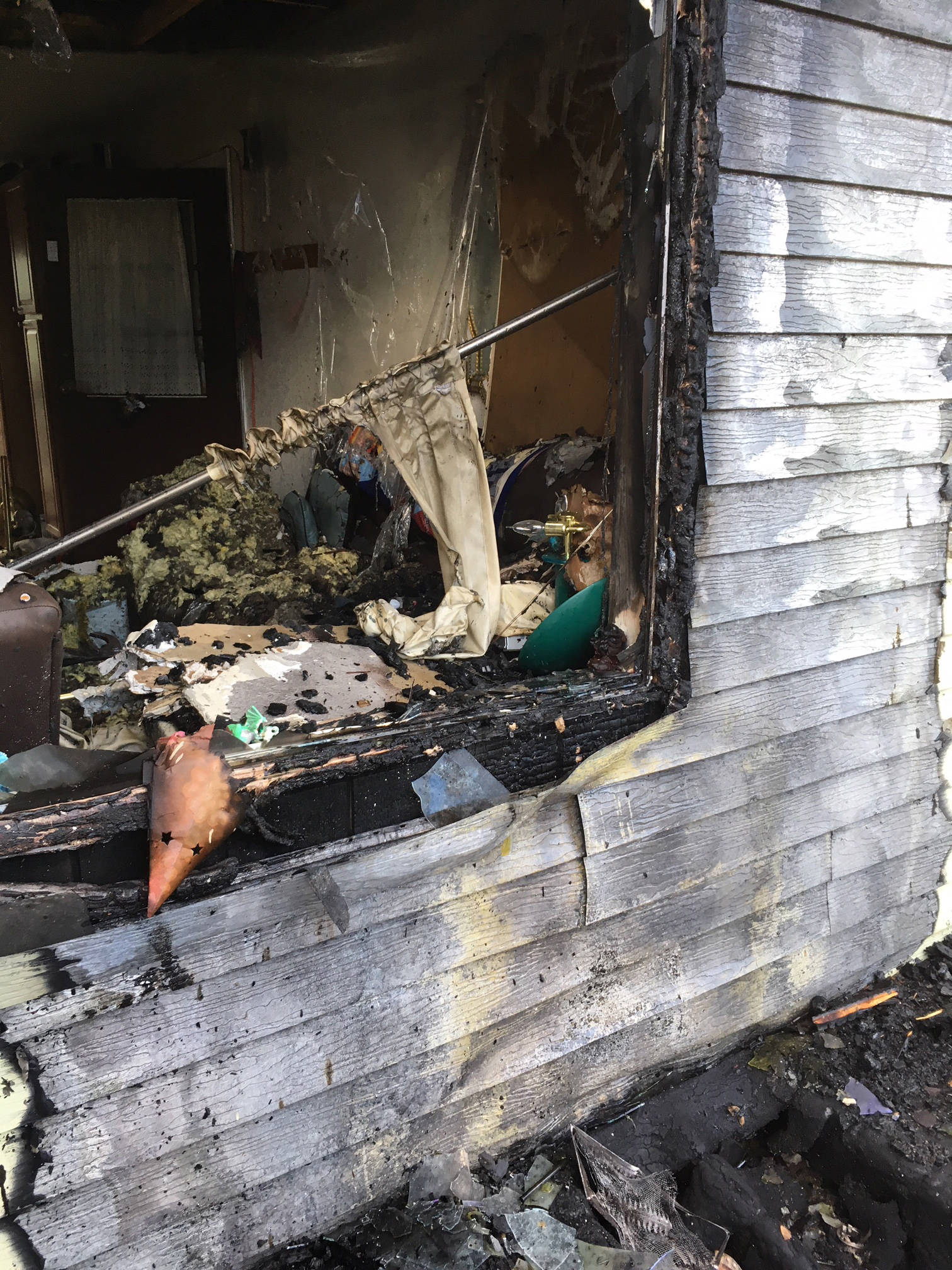 A fire July 13, 2018, on Danview Avenue in Homer, Alaska, badly damaged the porch and front of this home, but Homer Volunteer Fire Department and Kachemak Emergency Services firefighters kept the fire from destroying the home. (Photo provided)