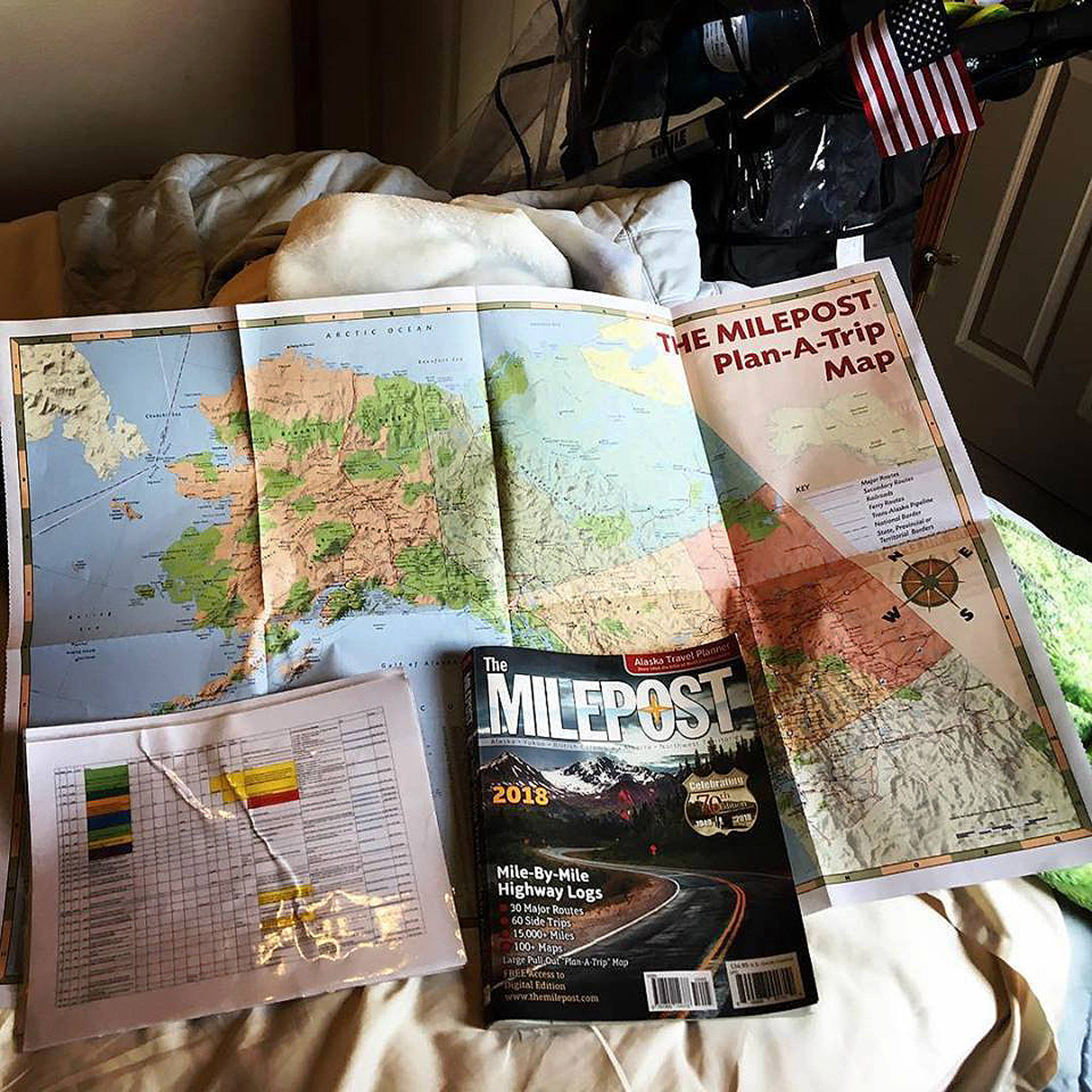 An assortment of maps cover a bed in a Facebook photo posted to Pete Kostelnicks account. (Photo provided by Pete Kostelnick)