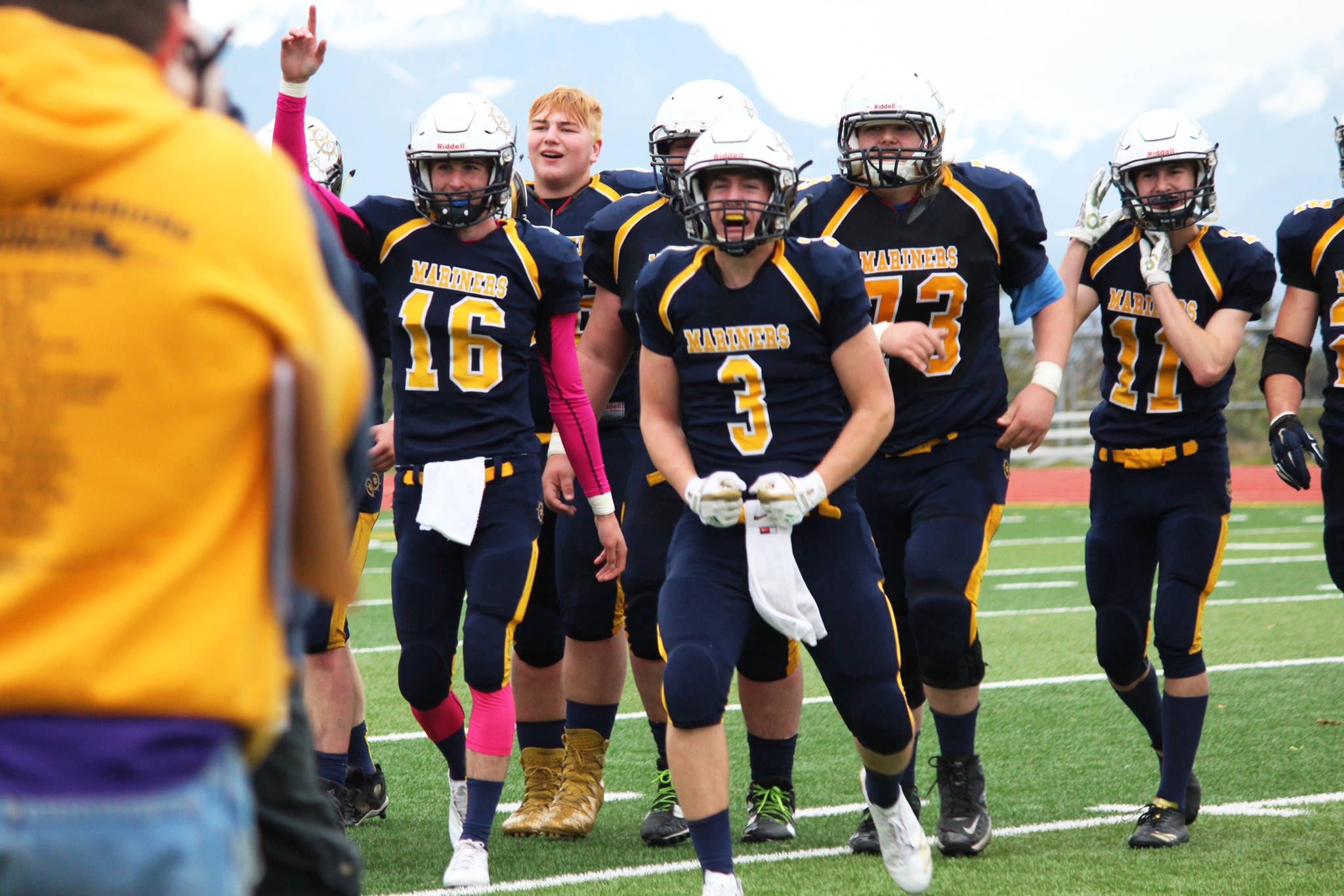 Justin Sumption (16) and Dawson Felde (3) come off the field celebrating with their teammates after defeating Ben Eielson High School in a playoff game Oct. 7, 2017 at Homer High School in Homer, Alaska. The Mariners went on to lose the ASAA First National Bowl Series Division III Championship game to the Barrow Whalers. (Photo by Megan Pacer/Homer News)