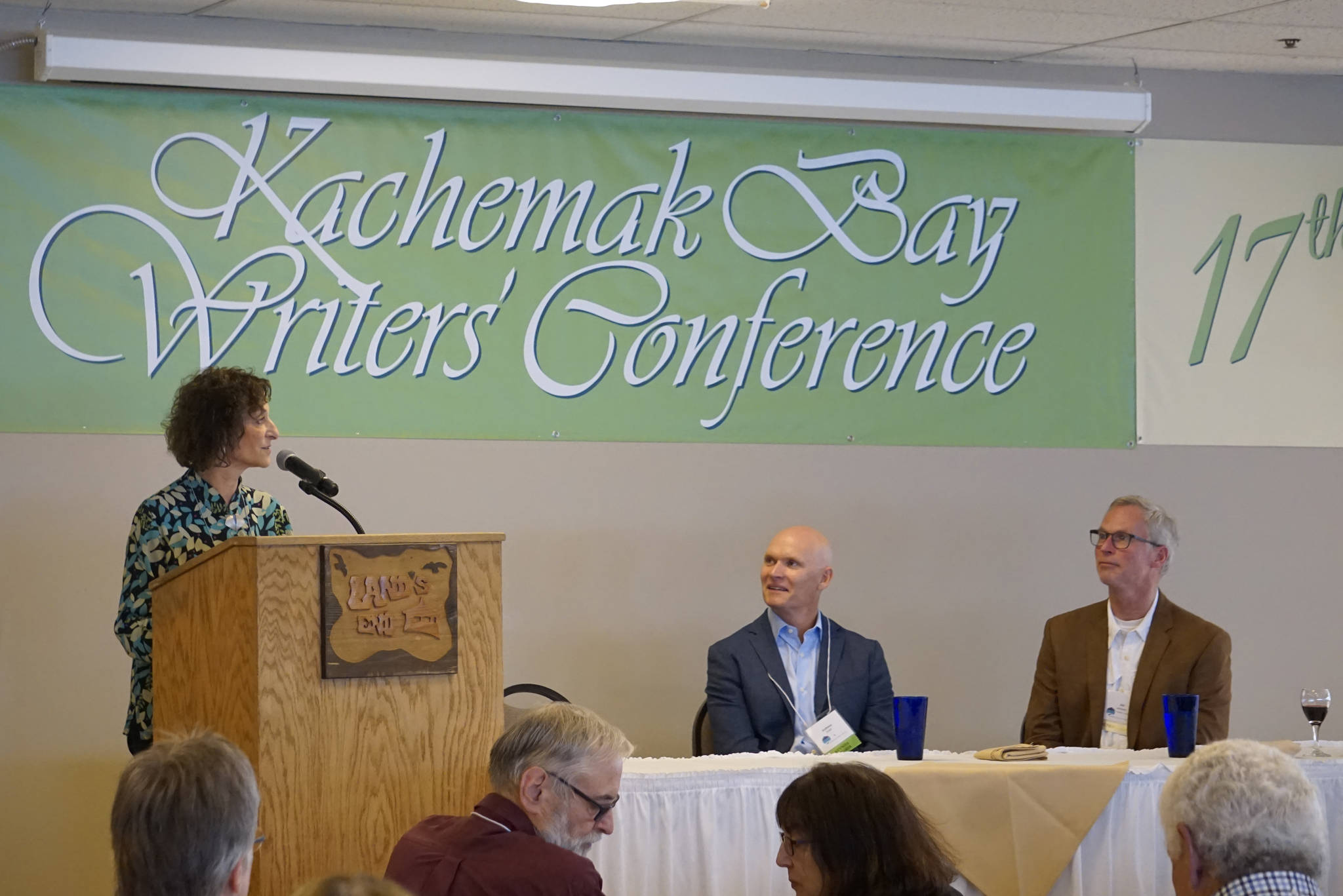 Kachemak Bay Campus Director Carol Swartz, left, speaks June 8, 2018, at the opening of the 2018 Kachemak Bay Writers’ Conference at Land’s End Resort in Homer, Alaska. (Photo by Michael Armstrong/Homer News)