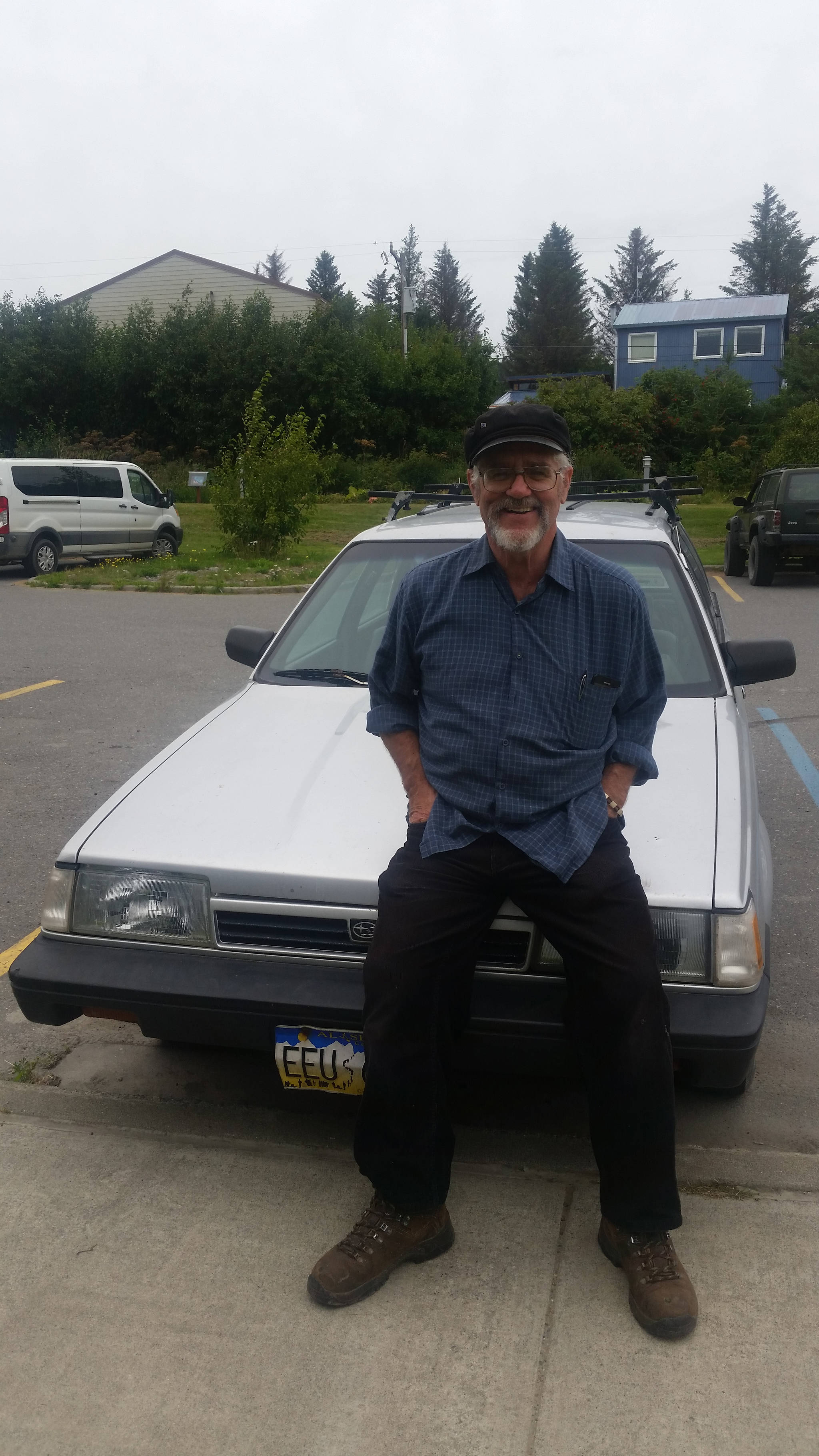 Bumppo Bremicker leans on his 1992 Subaru Loyale on Aug. 10, 2018 in the Homer Public Library parking lot in Homer, Alaska. (Photo by Mira Klein)