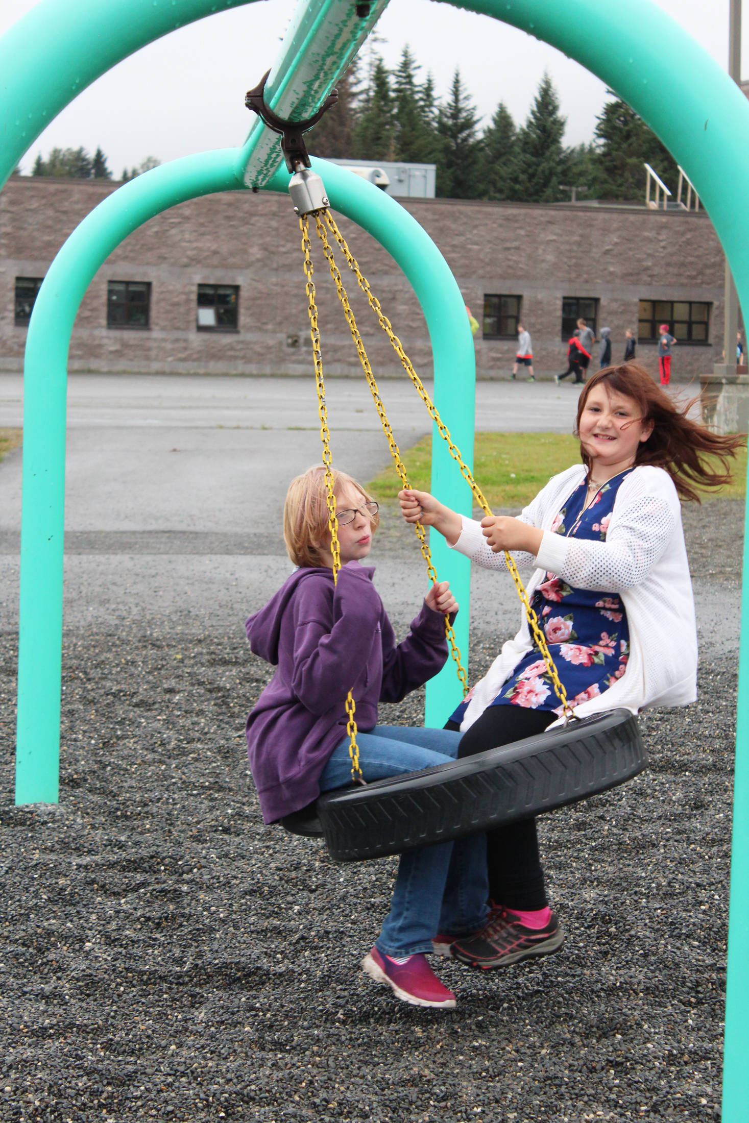 Emily Boyle and Hailey Van Sandt swing during recess on the first day of school at West Homer Elementary, Tuesday, Aug. 21, 2018 in Homer, Alaska. (Photo by Megan Pacer/Homer News)
