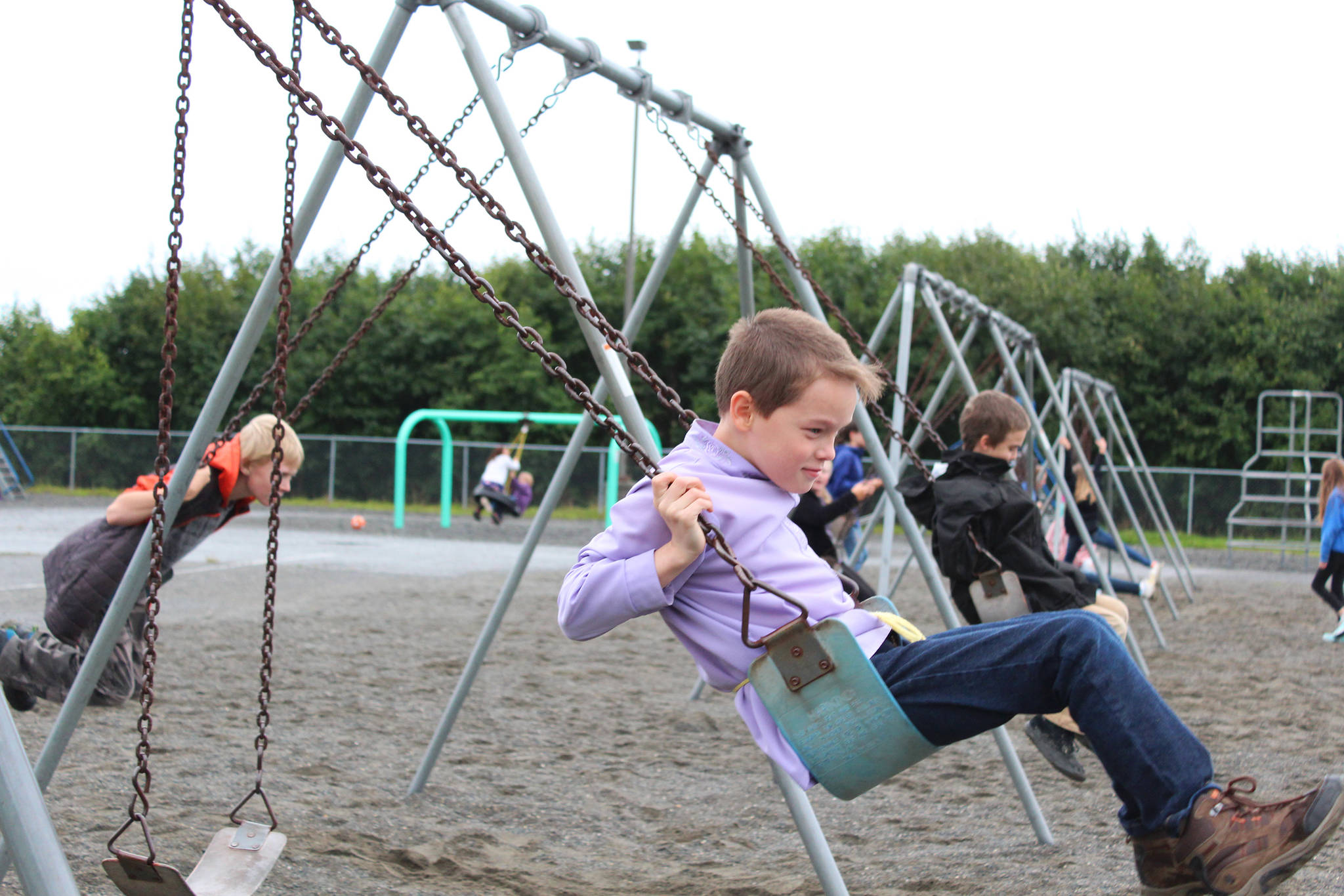 Daniel Kulikov works on his swinging form during recess on the first day of school at West Homer Elementary, on Tuesday, Aug. 21, 2018 at the school in Homer, Alaska. (Photo by Megan Pacer/Homer News)