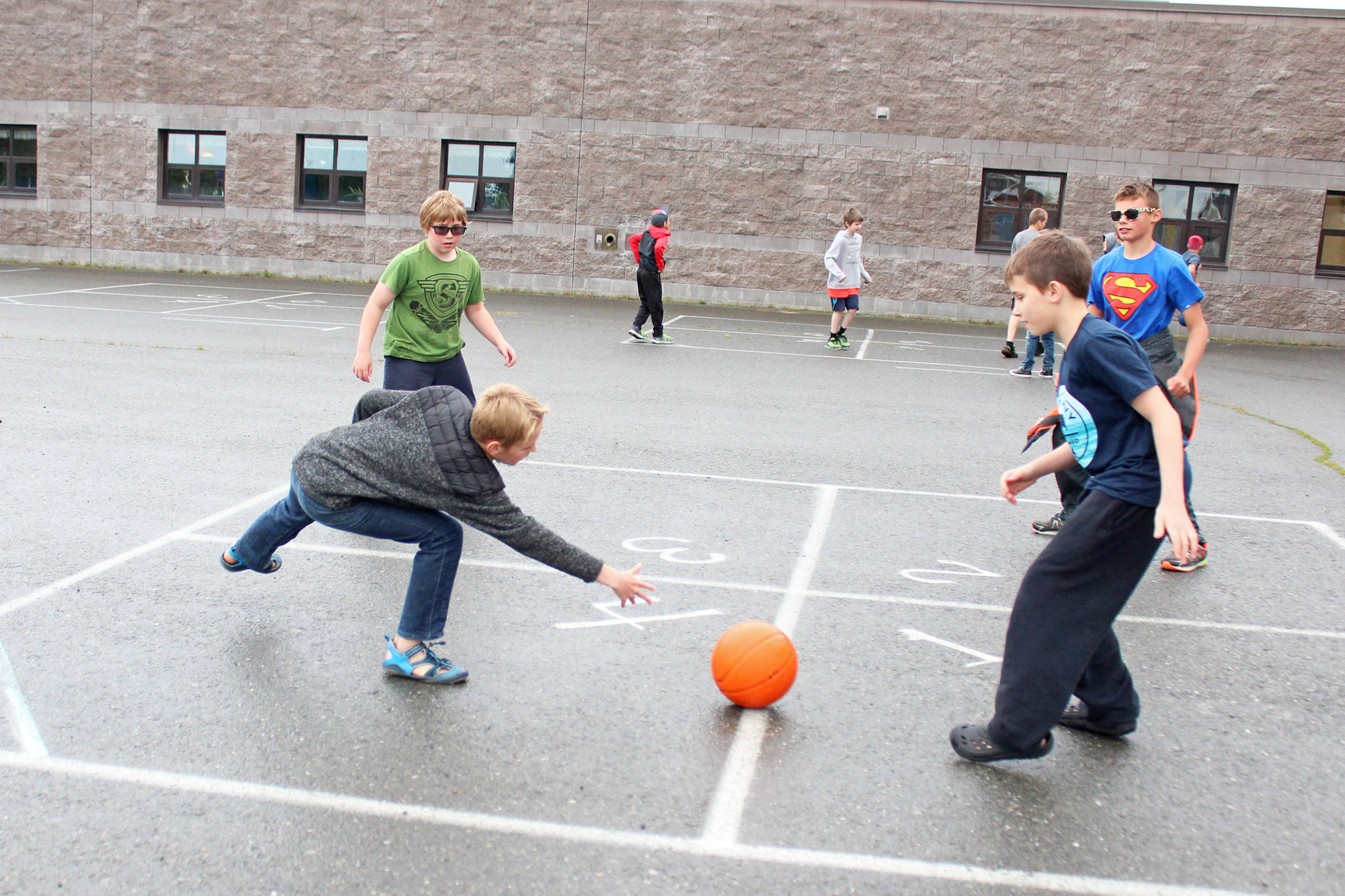 Jaxon Bourne, Sydney Phipps, Steel Seaton and Aiden Clark play a ball game in courtyard during recess on Tuesday, Aug. 18, 2018, the first day of school, at West Homer Elementary in Homer, Alaska. (Photo by Megan Pacer/Homer News)