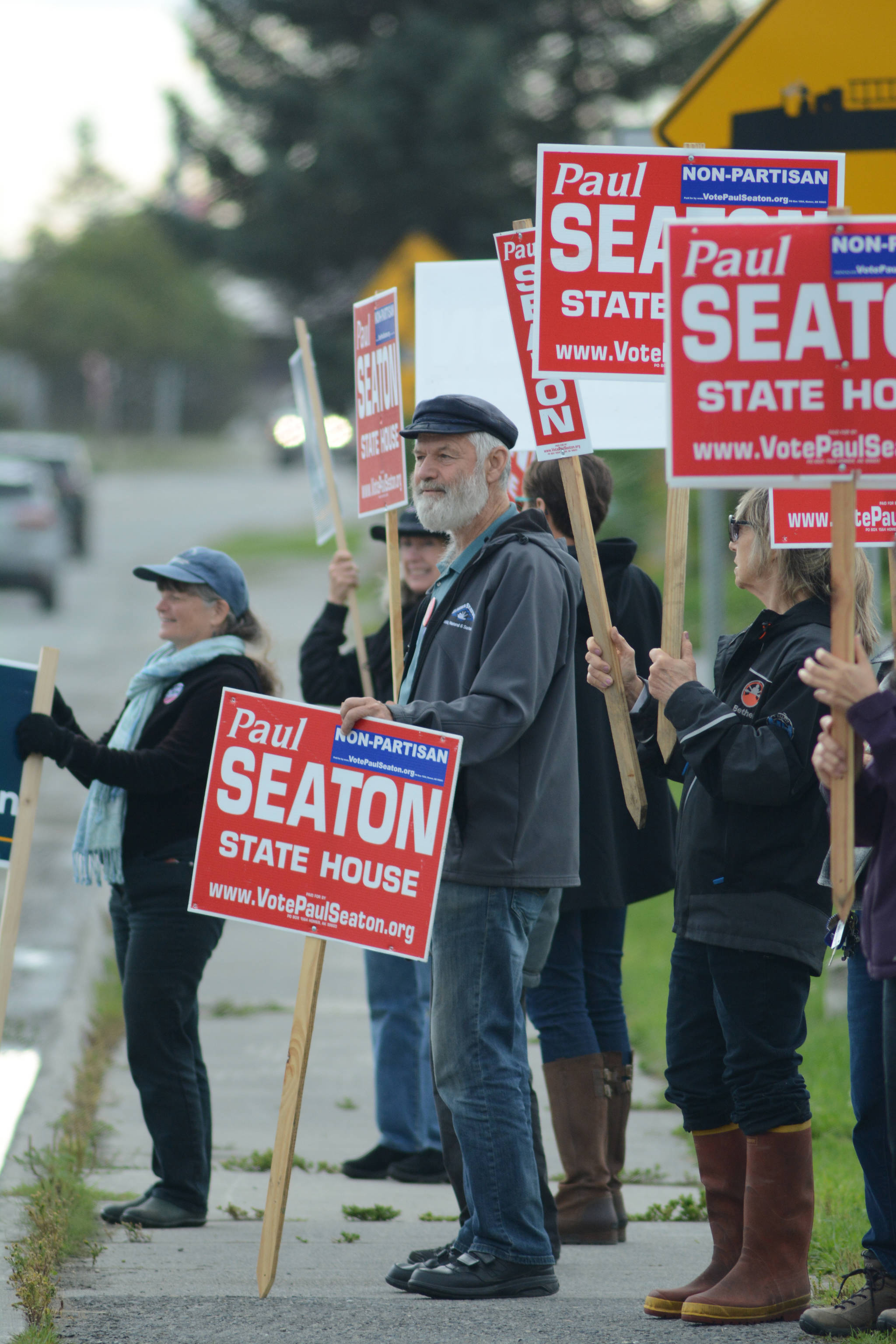 Rep. Paul Seaton, NP-Homer, center, is joined by supporters waving signs on primary election day, Aug. 21, 2018, at the corner of Lake Street and Pioneer Avenue in Homer. Seaton ran unapposed as a nonpartisan candidate for the Alaska Democratic Party seat. Also waving signs are supporters of Alyse Galvin, a nonpartisan candidate for the Democratic Party seat for U.S. Congress. Galvin won the Democratic Party nomination. (Photo by Michael Armstrong/Homer News)