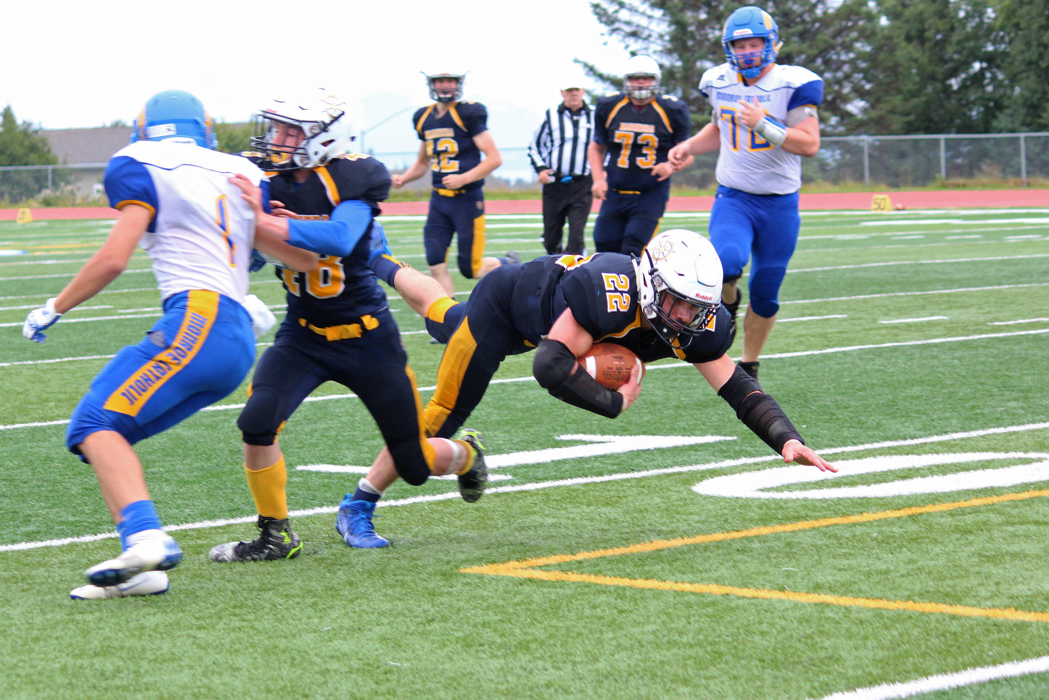 Homer junior Noah Fisk heads toward the ground after running the ball for the Mariners during their Saturday, Aug. 25, 2018 game against Monroe Catholic High School in Homer, Alaska. The Rams came out victorious, beating Homer 28-27. (Photo by Megan Pacer/Homer News)