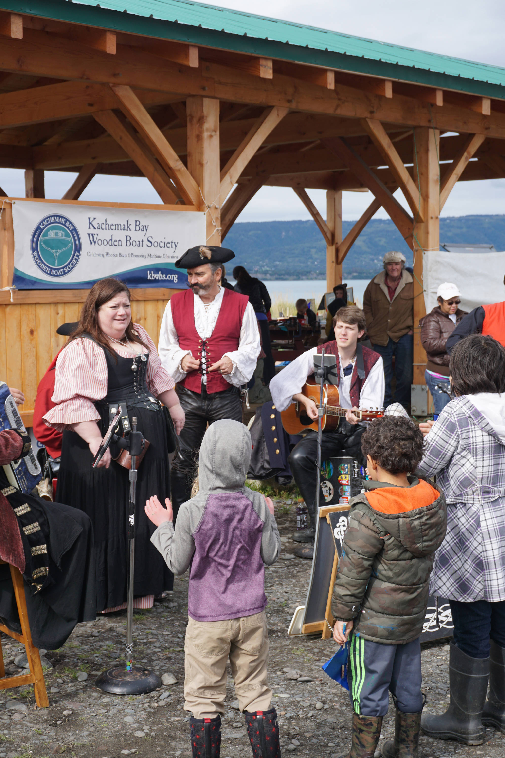 Erin Searcy-Dudgeon Wells of Rogues & Wenches, center, leads a sing along at last year’s Kachemak Bay Wooden Boat Society Festival on Sept. 2, 2017 at the Nick Dudiak Fishing Lagoon campground in Homer, Alaska. At left are Lucia Woofter and Lena Gonzales. At far right is Hunter Woofter, Devin Frey, second from right, and Bob Woofter. (File photo by Michael Armstrong, Homer News)