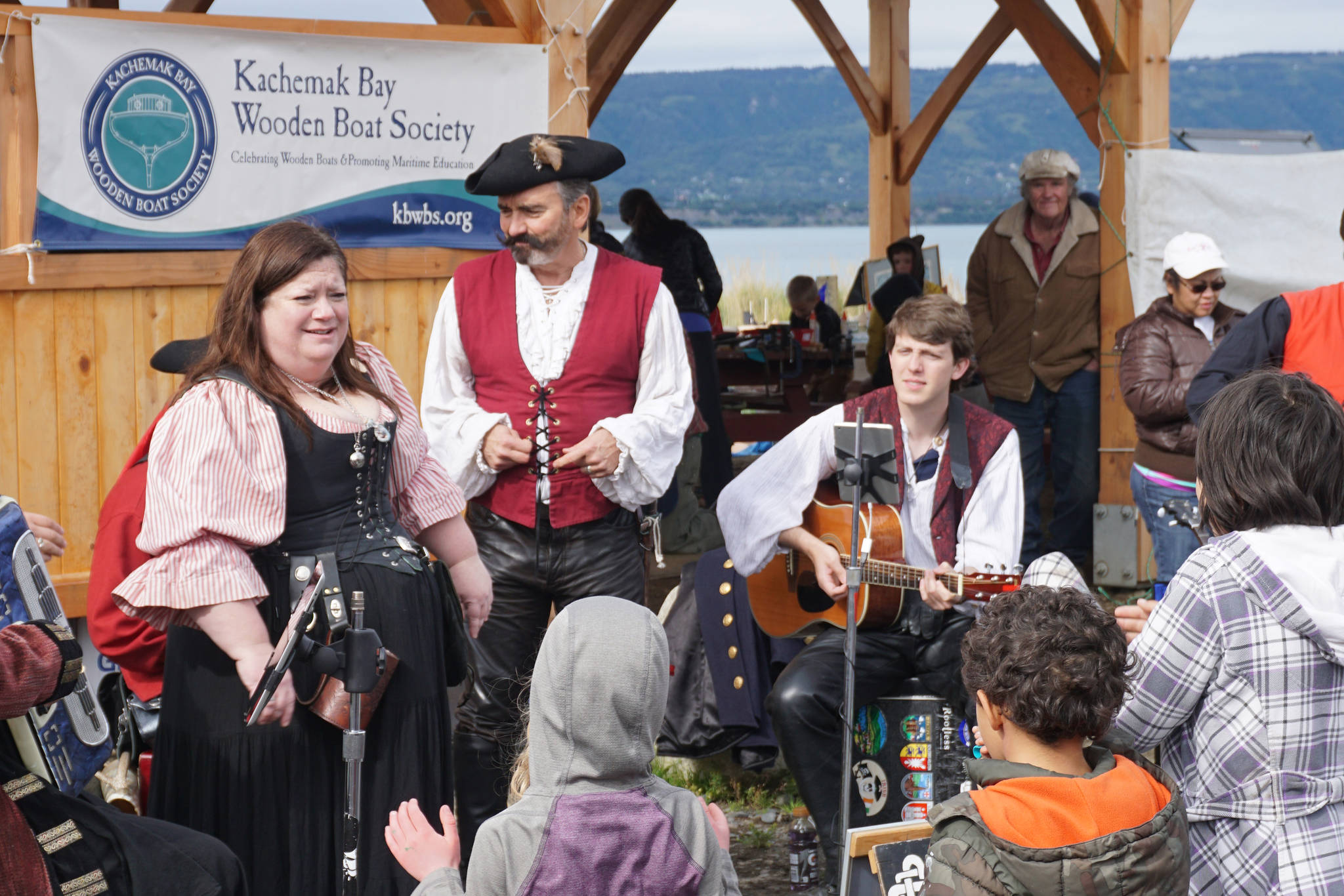 Erin Searcy-Dudgeon Wells of Rogues & Wenches, center, leads a sing along at the Kachemak Bay Wooden Boat Society Festival on Saturday at the Nick Dudiak Fishing Lagoon campground. At left are Lucia Woofter and Lena Gonzales. At far right is Hunter Woofter, Devin Frey, second from right, and Bob Woofter. (File photo by Michael Armstrong, Homer News)