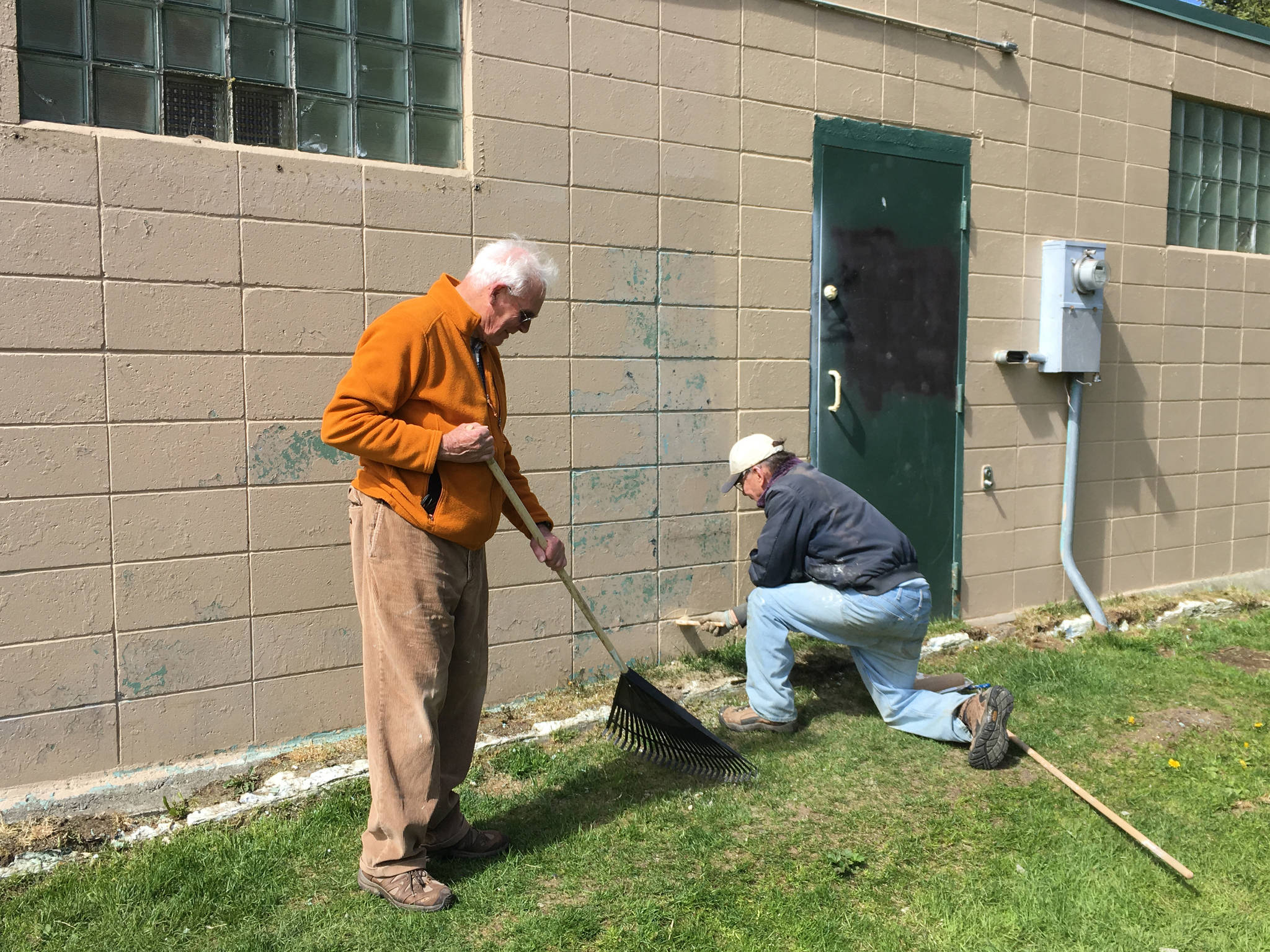 Homer-Kachemak Bay Rotarians Charlie Welles, left, rakes up paint chips while Maynard Gross, right, puts a new coat of paint on the restrooms at Ben Walters Park on June 9, 2018, in Homer, Alaska. (Photo provided)