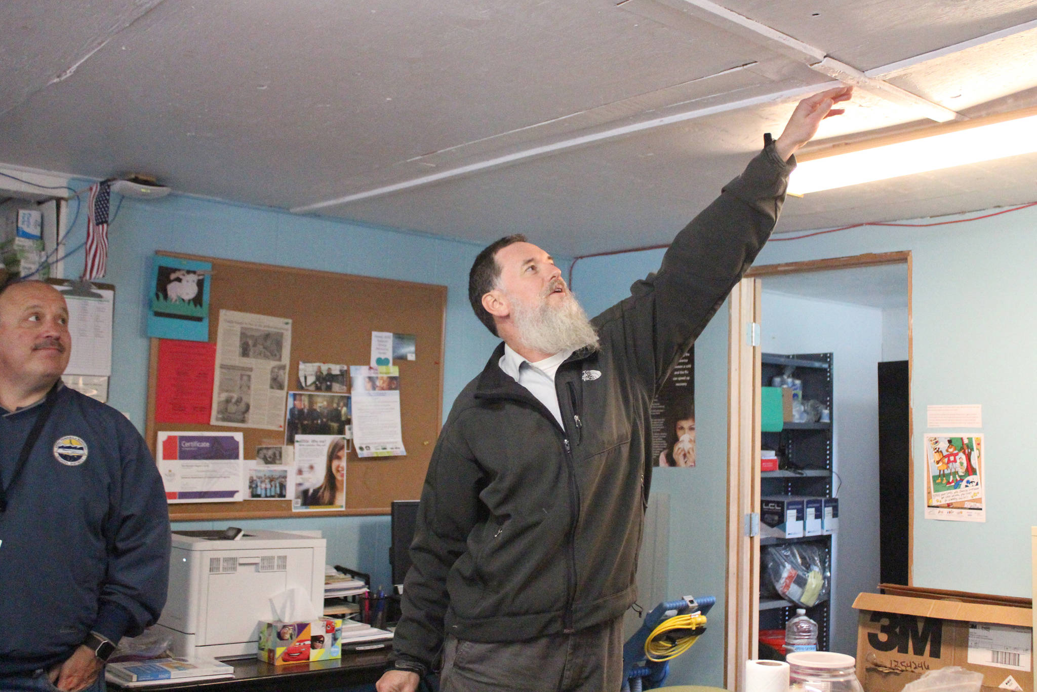 Mike Wojciak, regional principal of Voznesenka School and Kachemak Selo School, shows Kenai Peninsula Borough School District Superintendent Sean Dusek a spot in one of the Kachemak Selo School buildings where the ceiling dips and slants during a visit Thursday, Aug. 30, 2018 in the village at the head of Kachemak Bay, Alaska. The three buildings that make up the school have been in need of replacement for years. (Photo by Megan Pacer/Homer News)