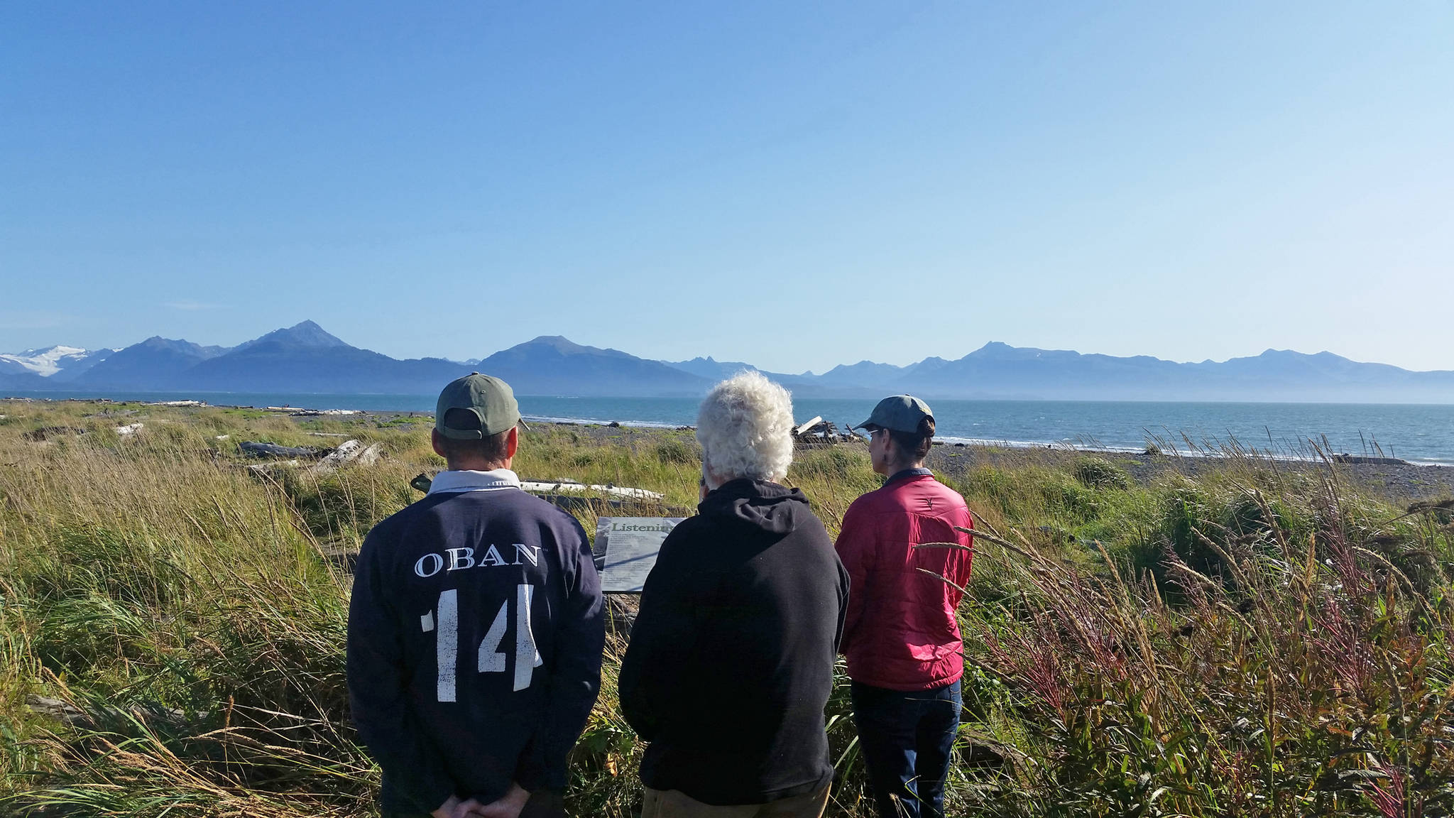 Participants in a pre-performance silent estuary walk contemplate Wendy Erd’s poetry on Sept. 2, 2018 at the Beluga Slough in Homer, Alaska. (Photo by Mira Klein)