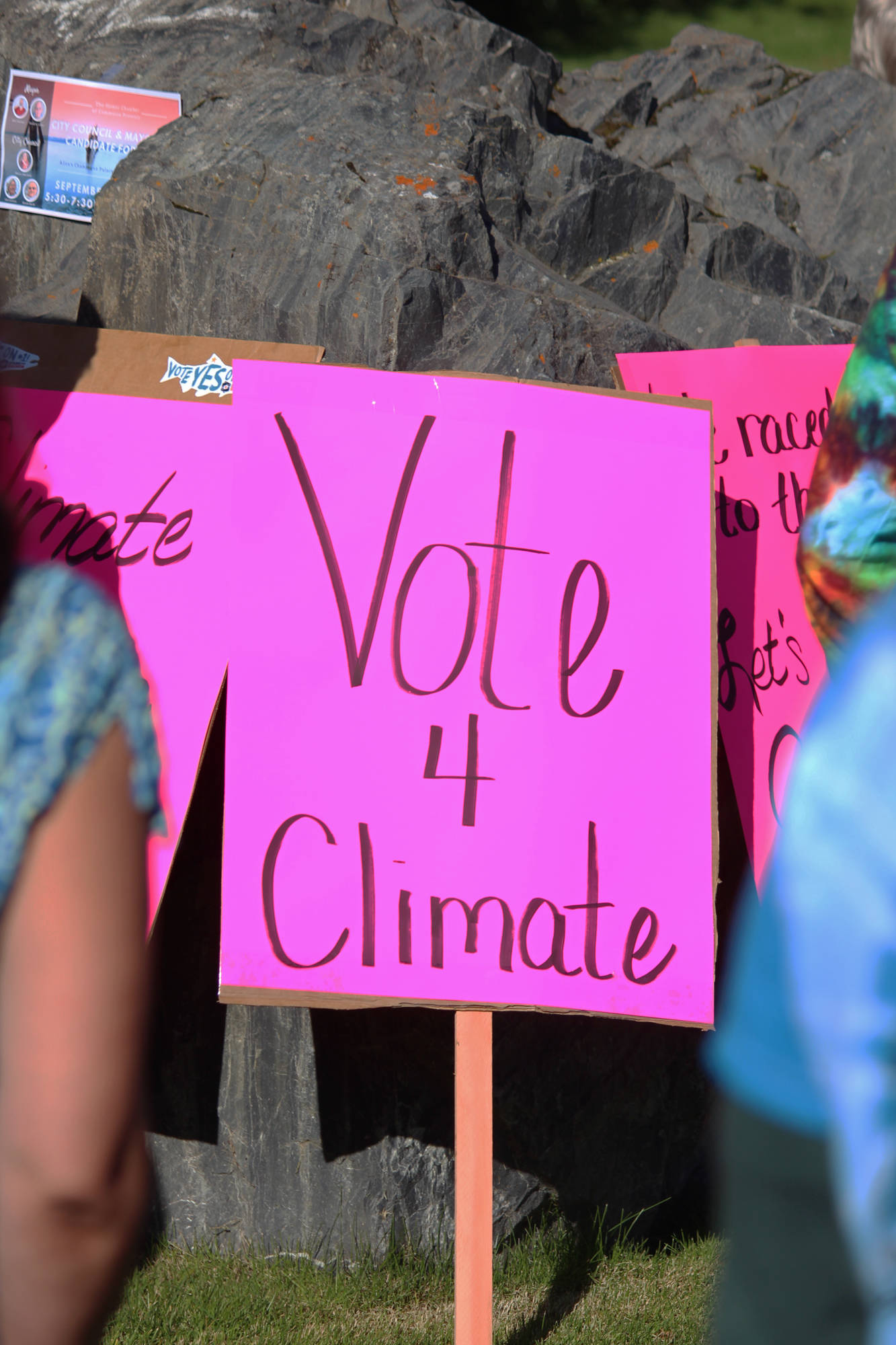 Several signs including this one which reads “Vote 4 Climate” lean up against a rock in WKFL Park on Saturday, Sept. 8, 2018 during the Rise for Climate, Jobs and Justice rally and march in Homer, Alaska. Larger rallies and marches were held nationally that day. (Photo by Megan Pacer/Homer News)