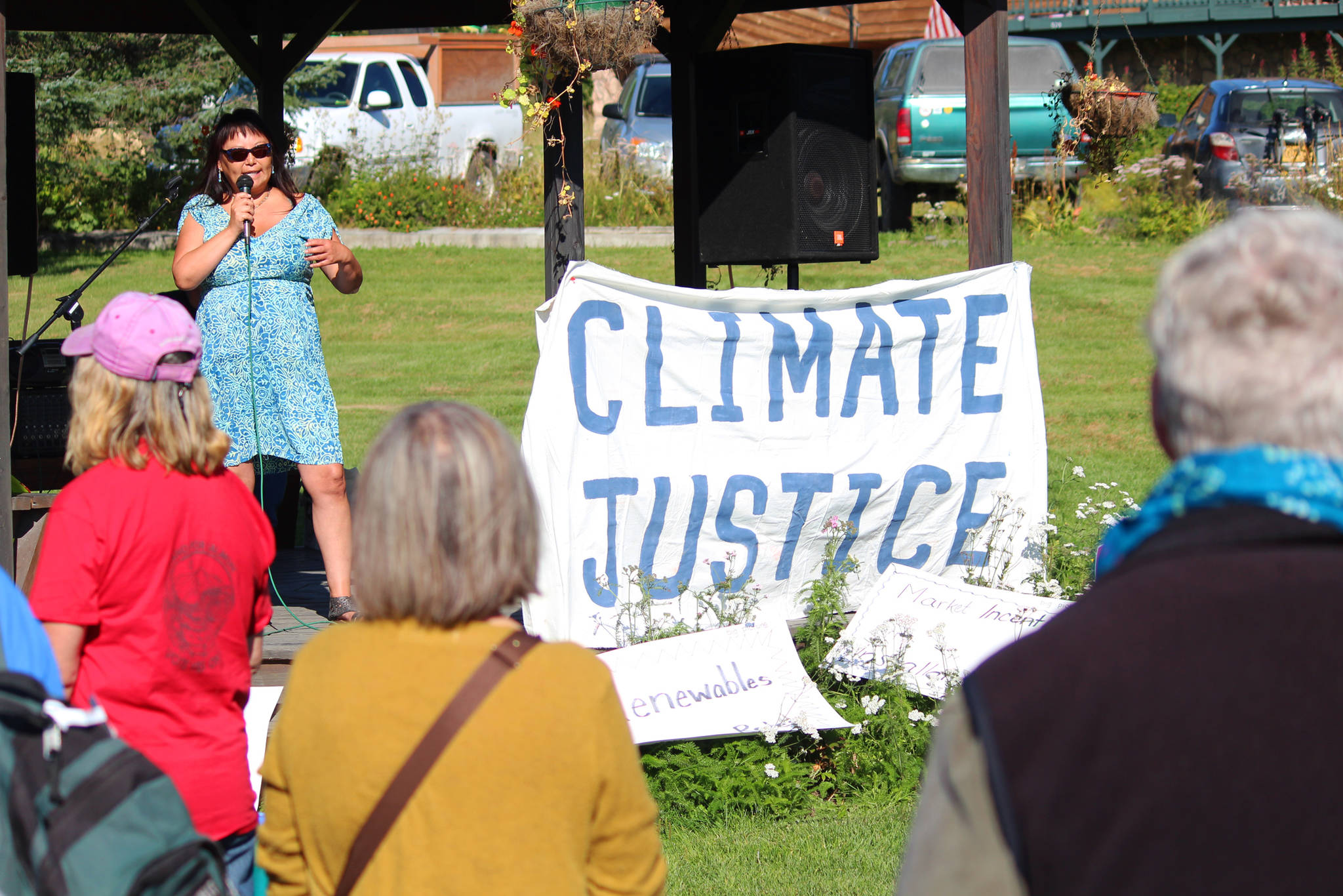 Area residents listen to Lydia Olympic, who worked with The Wilderness Society as a tribal advocate, as she gives a short speech Saturday, Sept. 8, 2018 at the Rise for Climate, Jobs and Justice rally and march at WKFL Park in Homer, Alaska. The local event, which ended in a march down to Mariner Park, was part of a larger movement of rallies held nationally on Sept. 8. (Photo by Megan Pacer/Homer News)