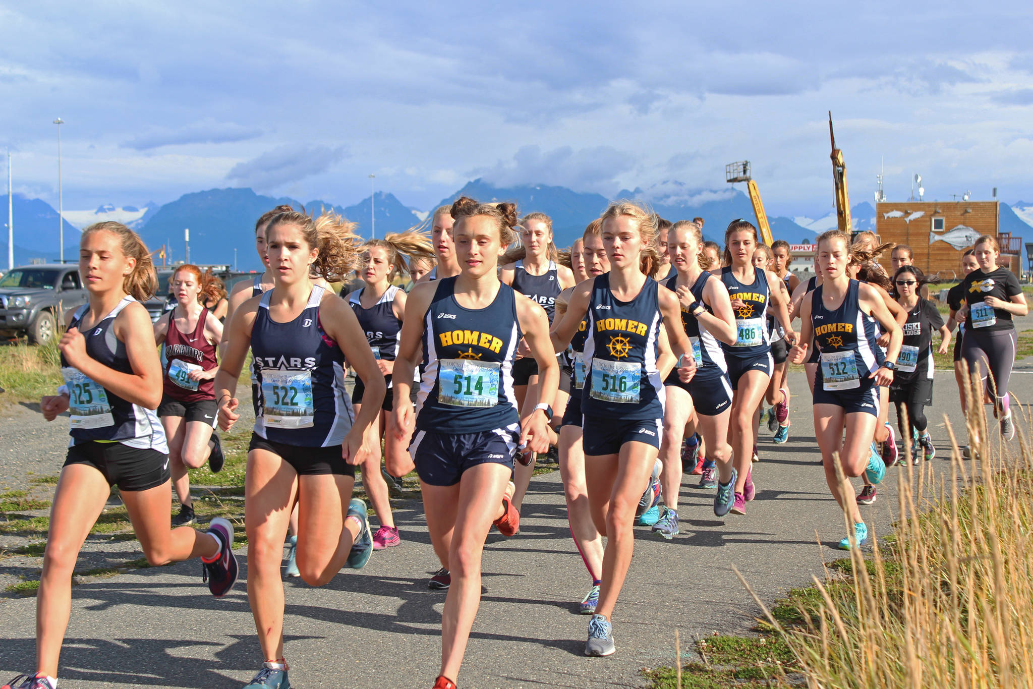 Athletes from Homer High School and Soldotna High School lead a pack of cross-country runners in the girls 5K race during the Homer Invitational on Friday, Sept. 7, 2018 on the Homer Spit in Homer, Alaska. The Soldotna girls team took first and Homer placed second by just one point. (Photo by Megan Pacer/Homer News)