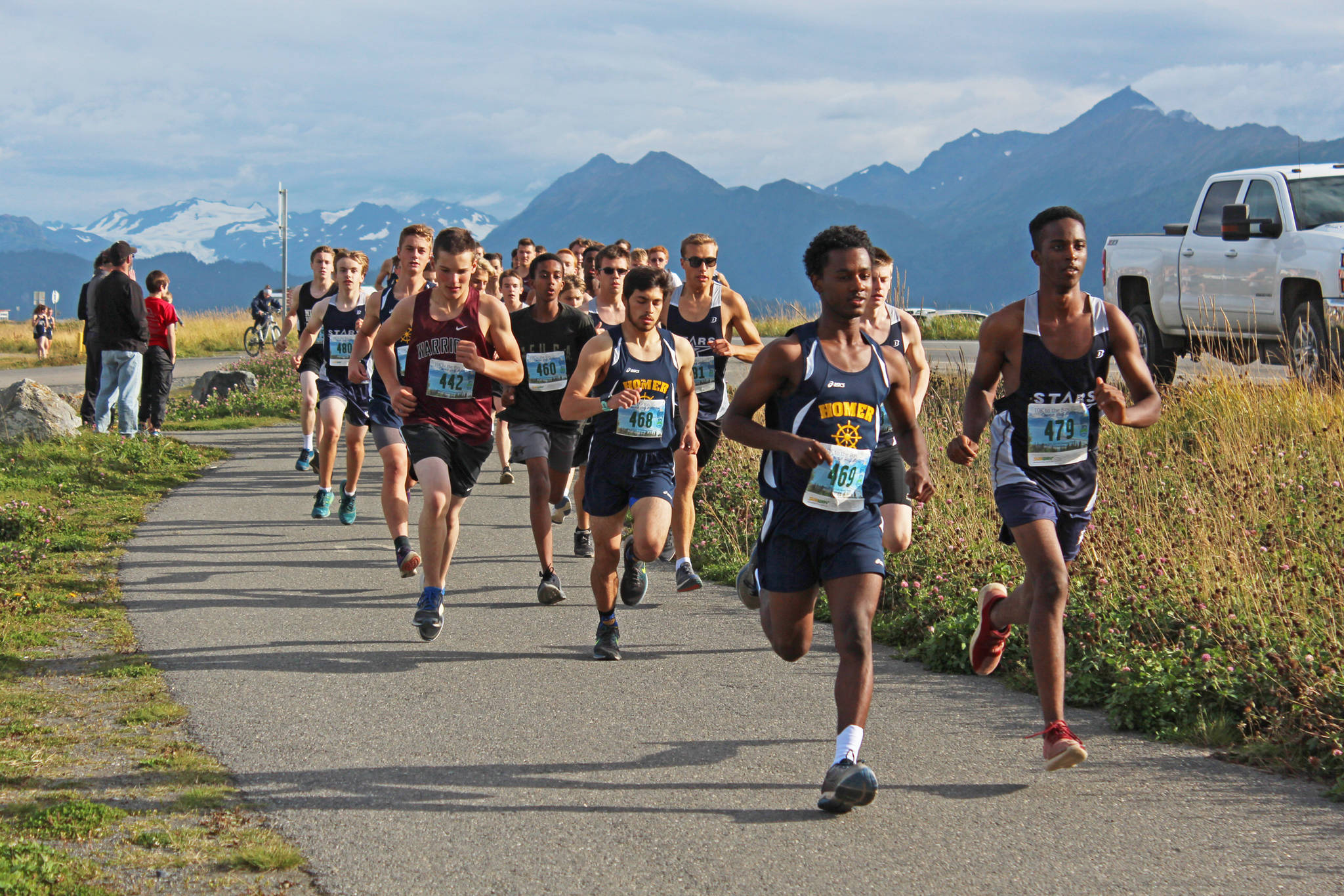 Cross-country runners take off from the starting line of the boys 5K Spit Run during the Homer Invitational on Friday, Sept. 7, 2018 on the Homer Spit in Homer, Alaska. The Soldotna boys team took first place, beating the Homer boys team by four points. (Photo by Megan Pacer/Homer News)