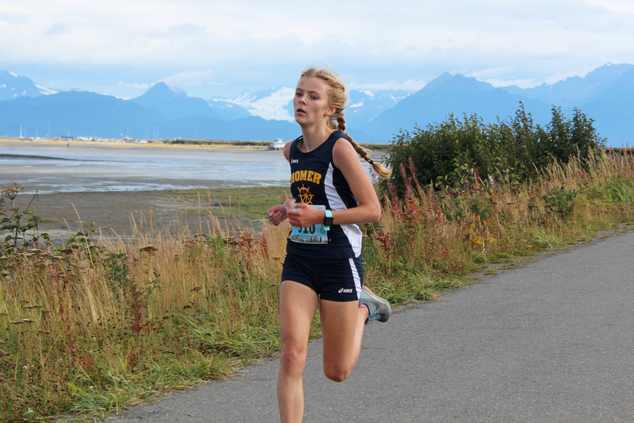 Homer sophomore Brooke Miller crosses the finish line of the girls 5K race during the Homer Invitational for cross-country Friday, Sept. 7, 2018 on the Homer Spit in Homer, Alaska. Miller and teammate Autumn Daigle took the top two spots in the varsity girls race. (Photo by Megan Pacer/Homer News)
