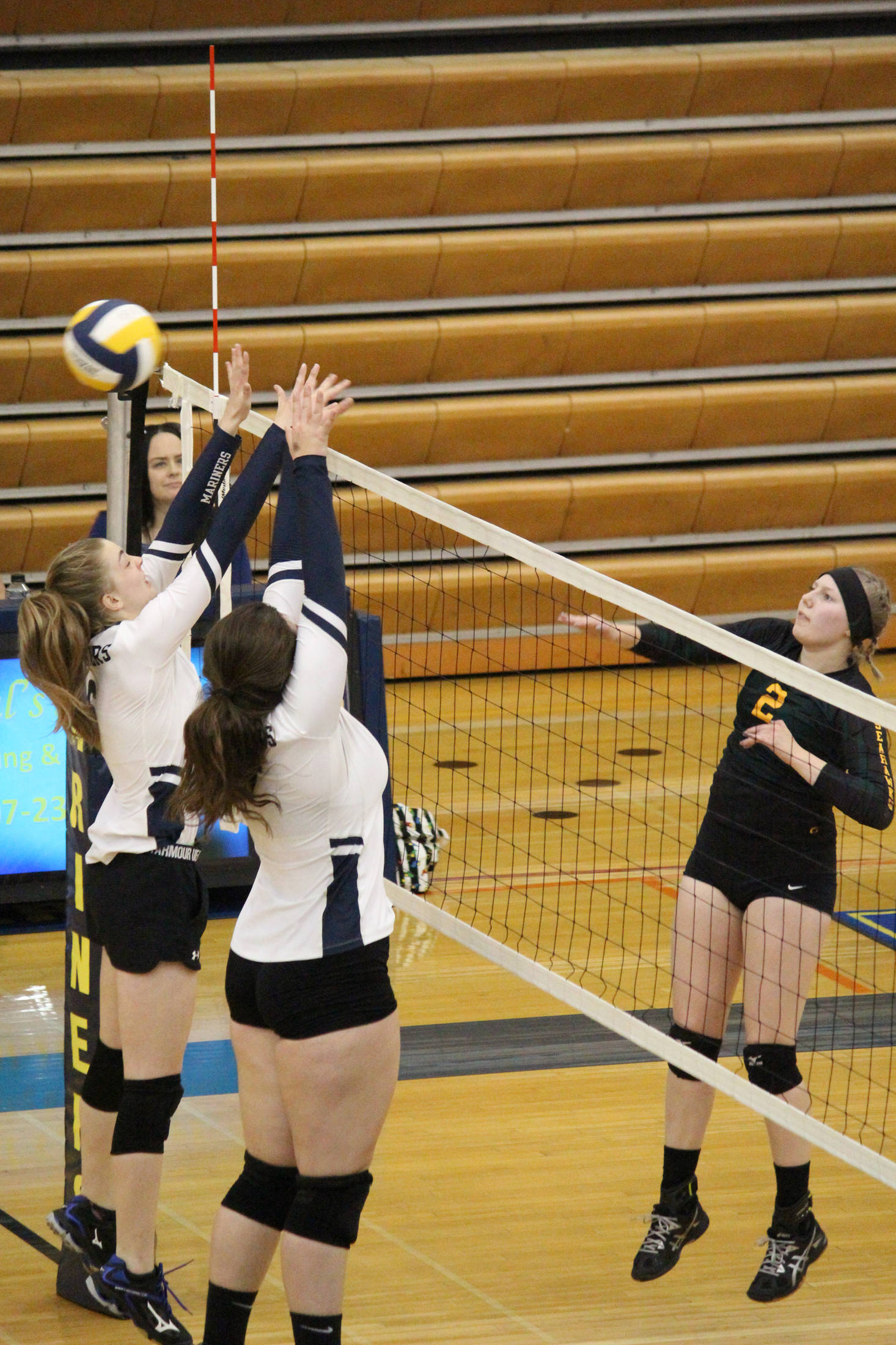 Homer’s Karmyn Gallios (left) and Brianna Hetrick (right) jump to block a hit from Seward’s Katelyn Sawyer-Lemme during a game Saturday, Sept. 22, 2018 in the Alice Witte Gymnasium in Homer, Alaska. (Photo by Megan Pacer/Homer News)
