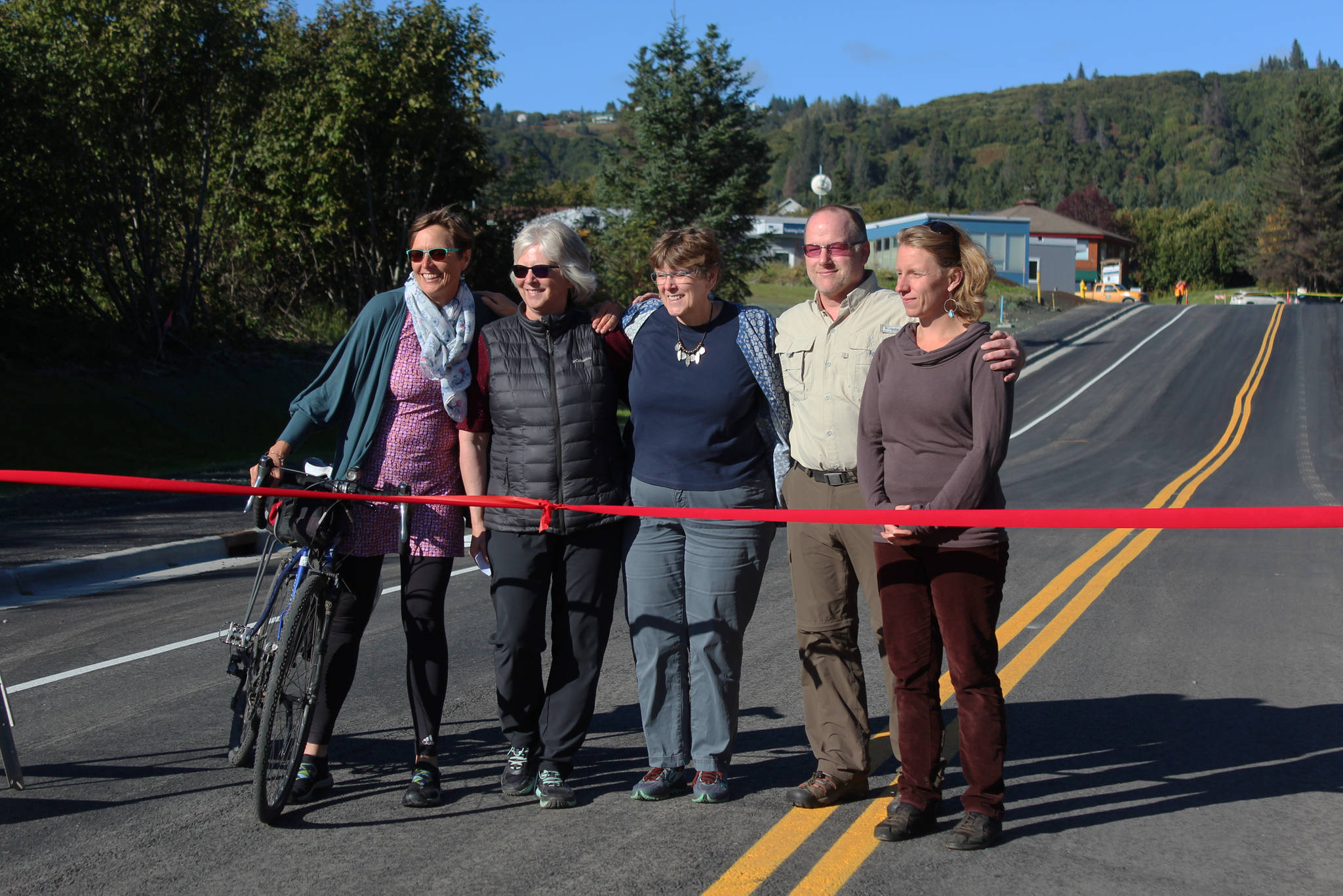 Five of the six Homer City Council members (from left to right: Donna Aderhold, Shelly Erickson, Caroline Venuti, Heath Smith and Rachel Lord) smile at the grand opening for the extended Greatland Street on Tuesday, Sept. 25, 2018 in Homer, Alaska. (Photo by Megan Pacer/Homer News)