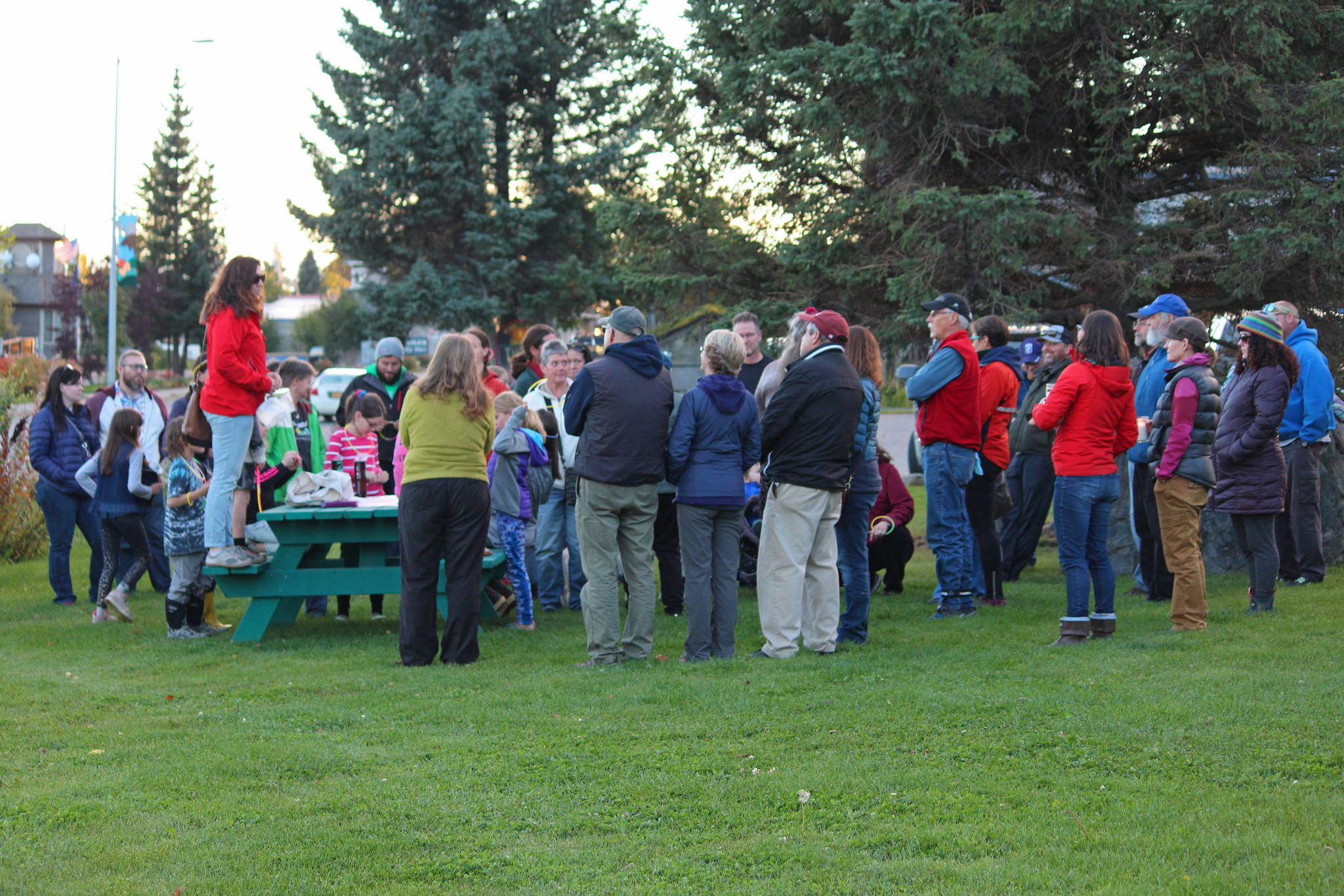 Participants in a Light the Night march listen to Kerri-Ann Baker of The Bearded Sister give a short speech before leading people on the walk Saturday, Sept. 29, 2018 from WKFL Park in Homer, Alaska. This is the first time a Light the Night march has been held in Homer, with the purpose being to remember those lost to addiction and those living in recovery. (Photo by Megan Pacer/Homer News)