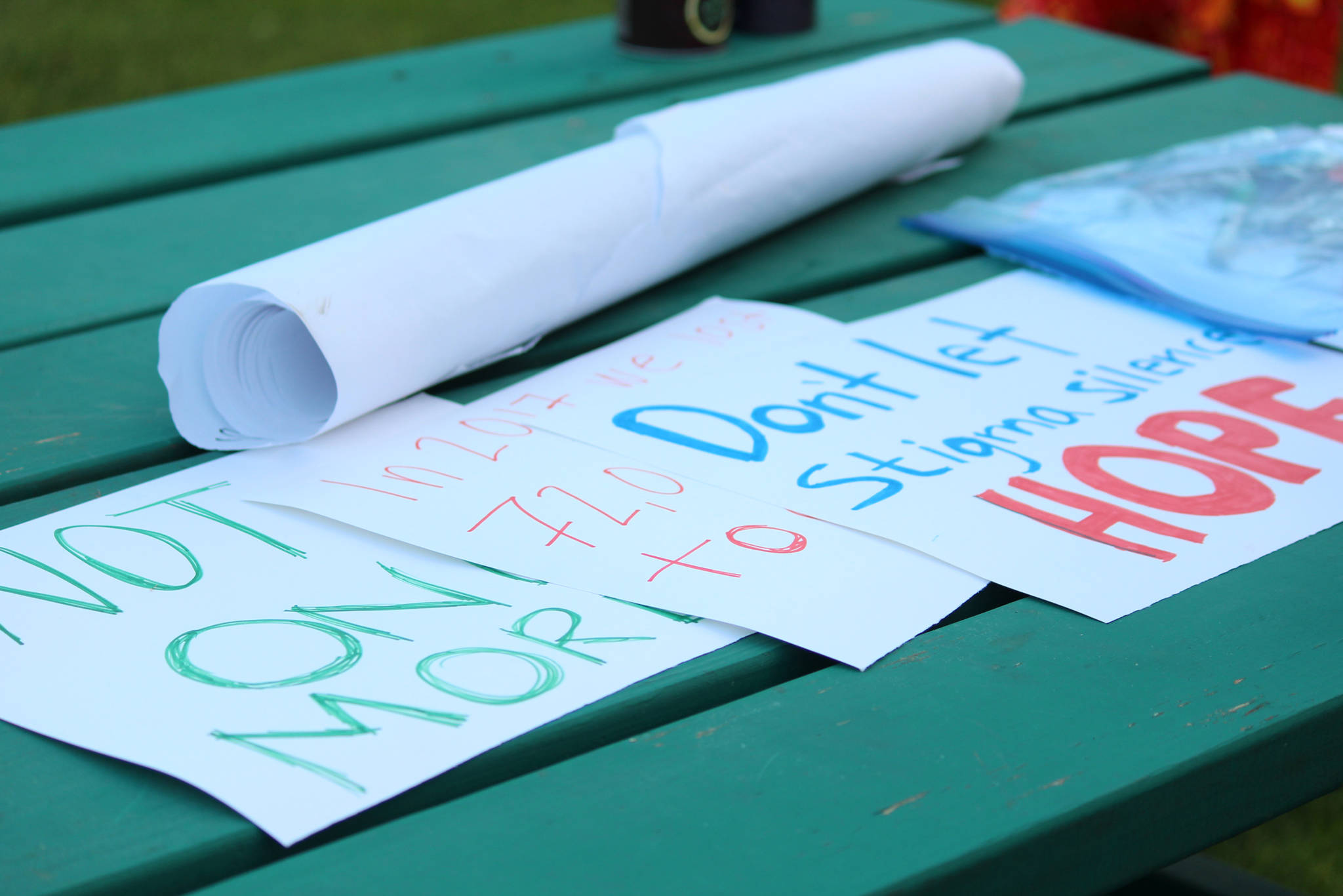 Signs with positive messages about overcoming addiction stigma and celebrating recovery rest on a picnic table before Homer’s first Light the Night march Saturday, Sept. 29, 2018 at WKFL Park in Homer, Alaska. (Photo by Megan Pacer/Homer News)