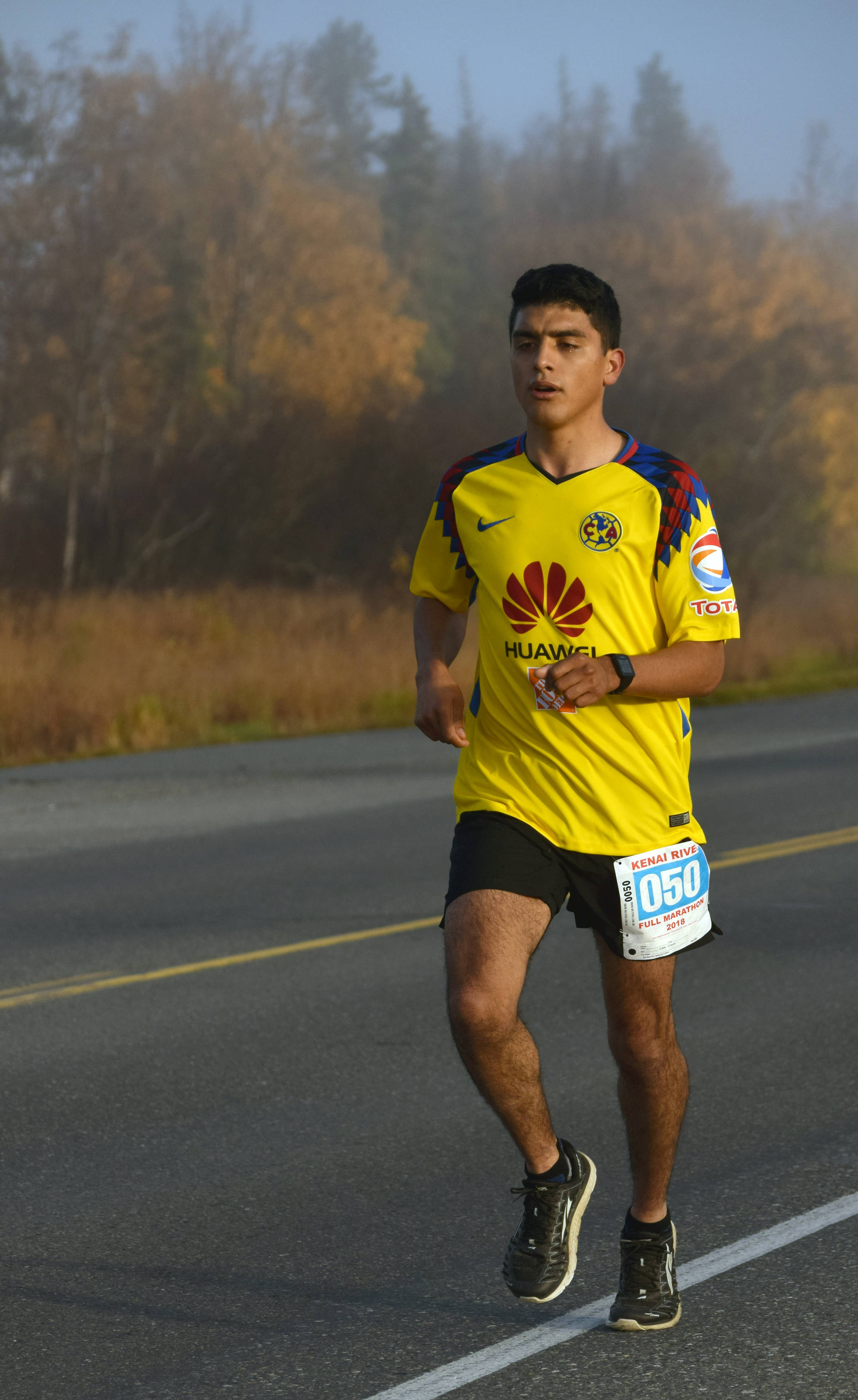 Homer’s Pedro Ochoa runs on Bridge Access Road on the way to victory in the Kenai River Marathon on Sunday, Sept. 30, 2018. (Photo by Jeff Helminiak/Peninsula Clarion)