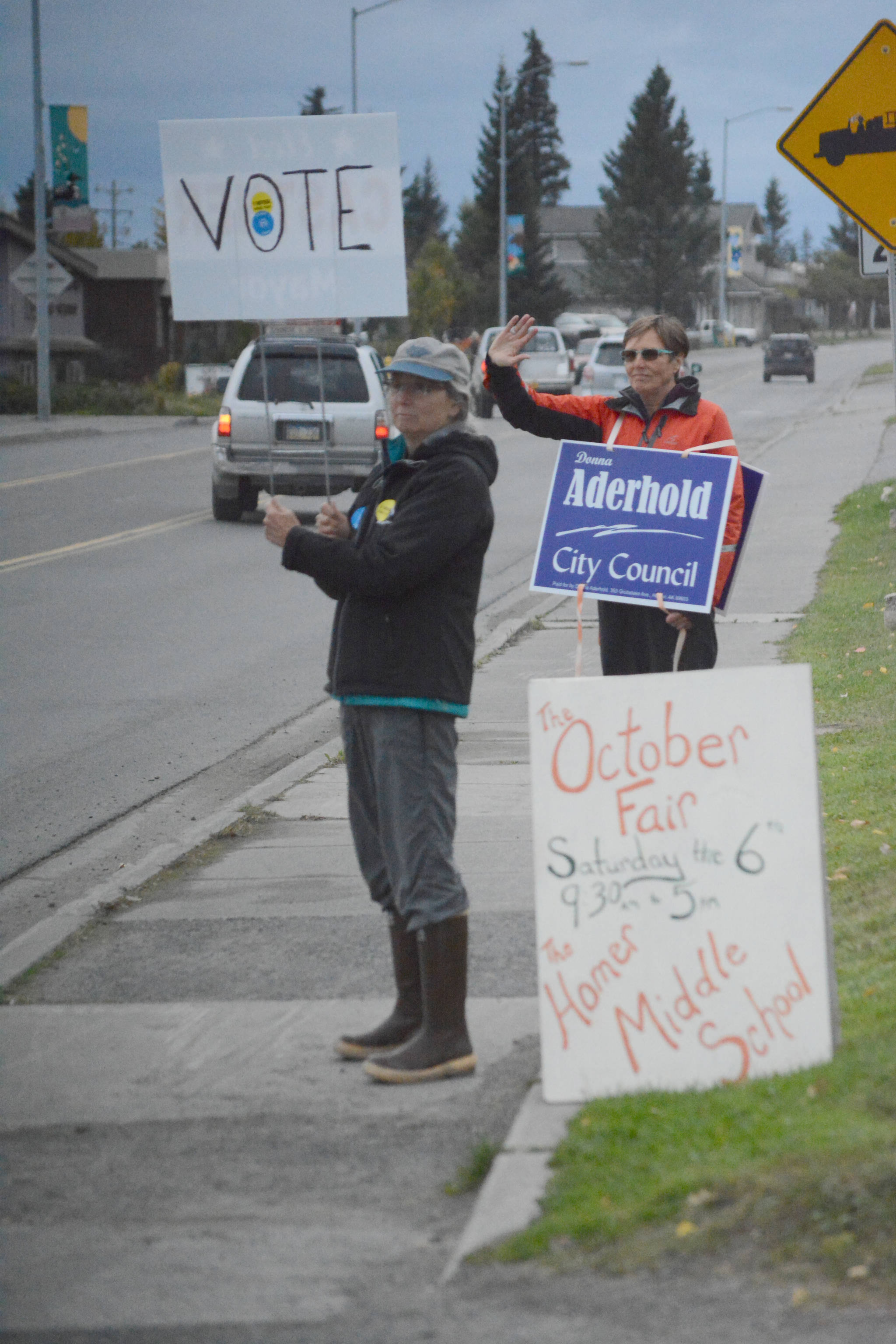Nancy Lord, left, and Donna Aderhold, right, wave signs on Pioneer Avenue on election day, Tuesday, Oct. 2, 2018, in Homer, Alaska. Lord campaigned for her husband, Ken Castner, the apparent winner in the city of Homer mayoral race. Aderhold was the top vote-getter for the race for two Homer City Council seats. (Photo by Michael Armstrong/Homer News)
