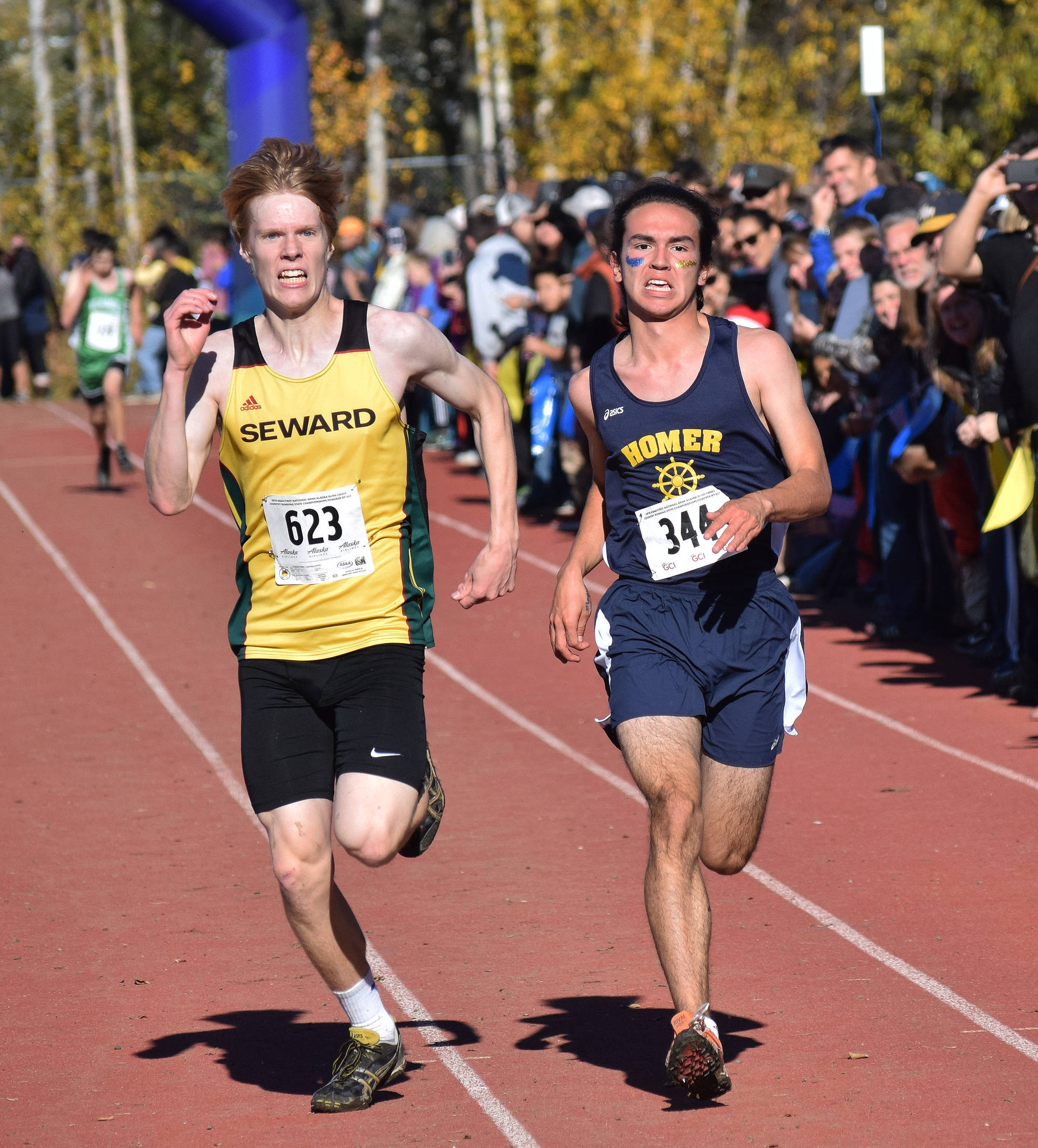 Seward’s Max Pfeiffenberger (left) and Homer’s Bill Rich race for 16th place in the Division II boys race Saturday at the ASAA state cross-country running championships at the Bartlett Trails in Anchorage. (Photo by Joey Klecka/Peninsula Clarion)