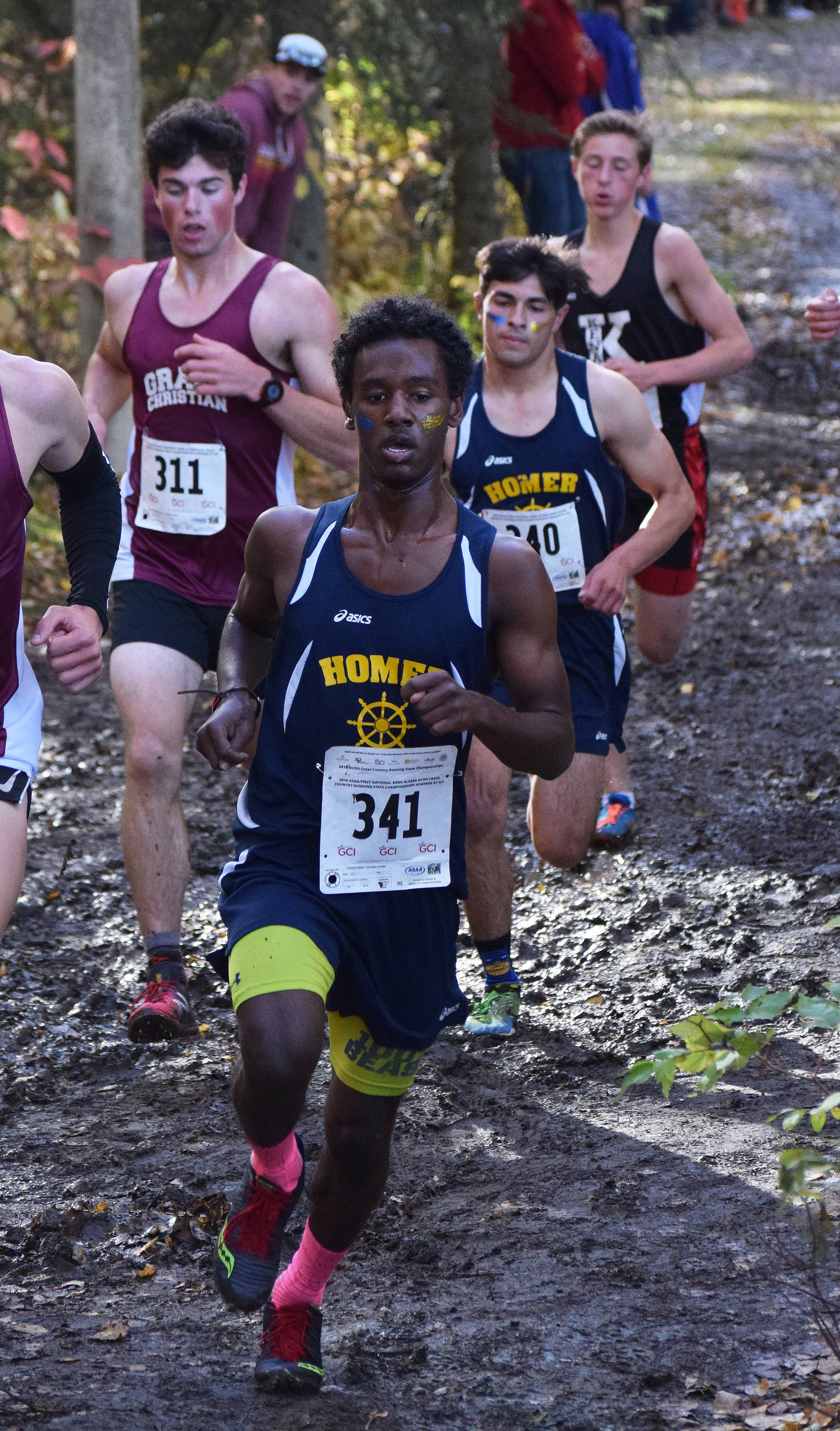 Homer runners Eyoab Knapp (341) and Luciano Fasulo (behind) and Kenai Central runner Maison Dunham race with the pack in the Division II boys race Saturday at the ASAA state cross-country running championships at the Bartlett Trails in Anchorage. (Photo by Joey Klecka/Peninsula Clarion)