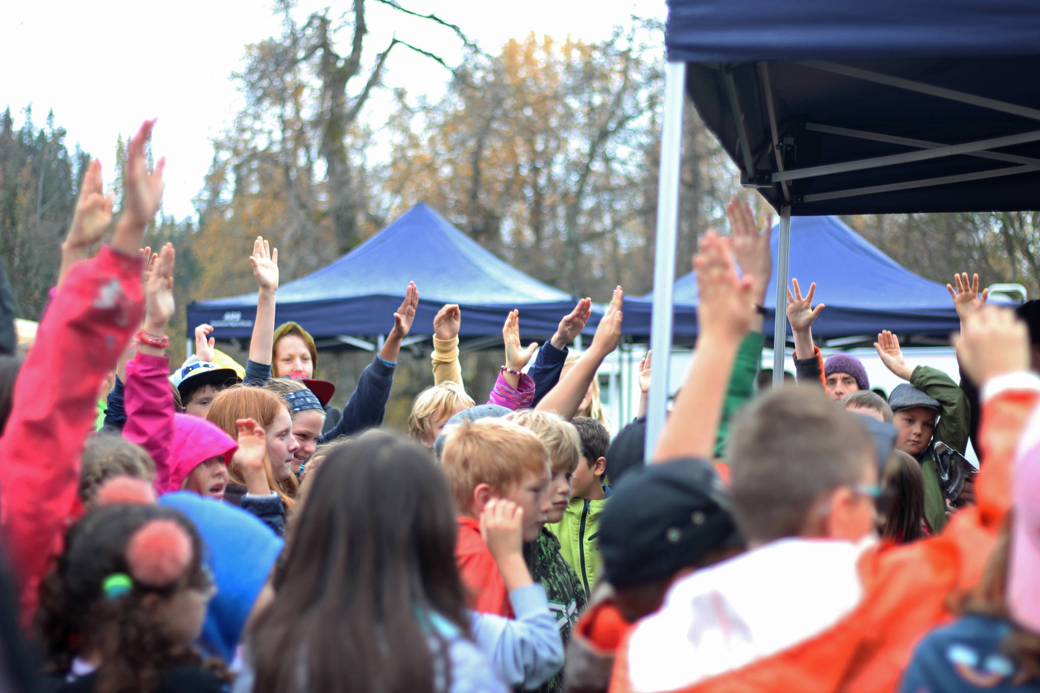 Students from Chapman School and Fireweed Academy raise their hands to answer a question about salmon during an educational egg take trip Thursday, Oct. 4, 2018 at the Anchor River in Anchor Point, Alaska. (Photo by Megan Pacer/Homer News)