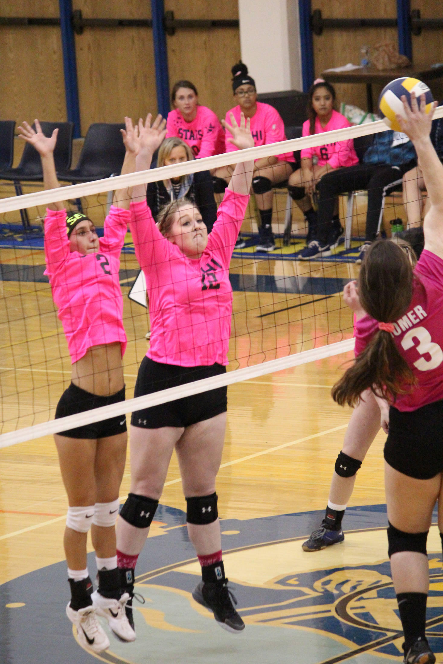 Soldotna High School’s Carsen Brown (left) and Bailey Leach (right) jump to block a spike from Homer’s Tonda Smude during their game Tuesday, Oct. 9, 2018 at the Alice Witte Gymnasium in Homer, Alaska. (Photo by Megan Pacer/Homer News)
