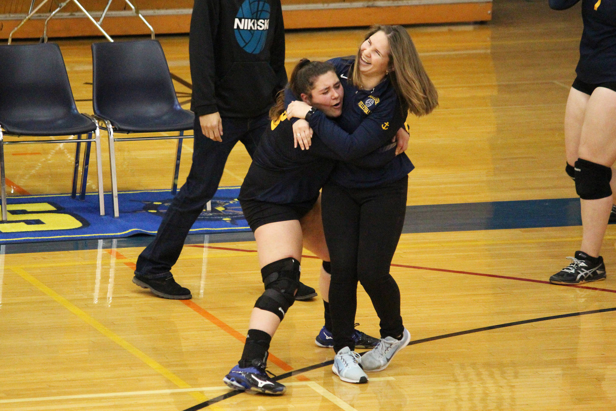 Homer senior Brianna Hetrick and volleyball coach Sara Pennington celebrate just after winning their last home game of the season against Nikiski Middle-High School on Saturday, Oct. 13, 2018 in Homer, Alaska. The Mariners haven’t beaten Nikiski in a regular game since 2014. (Photo by Megan Pacer/Homer News)