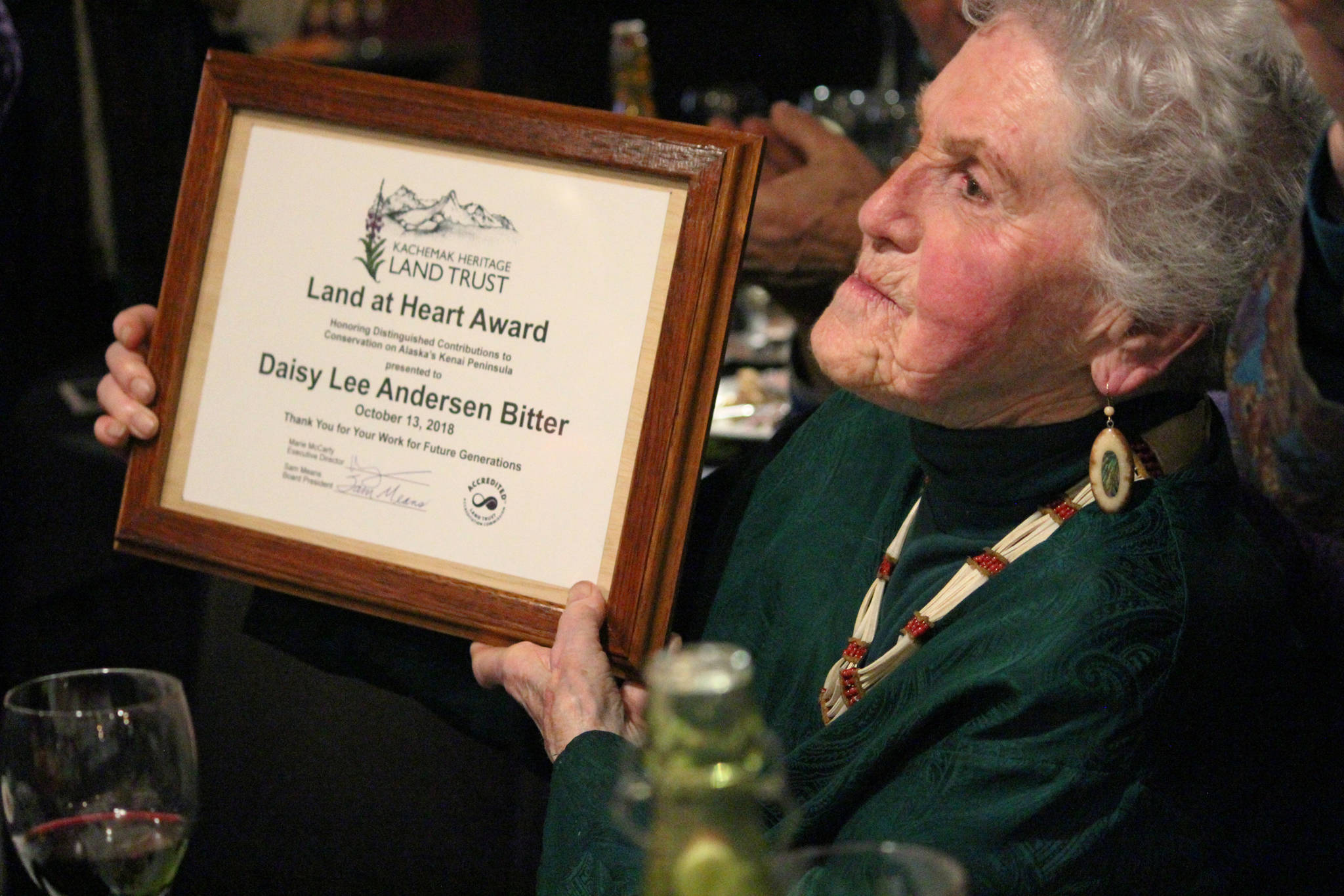 Daisy Lee Anderson Bitter accepts the 2018 Land at Heart Award from the Kachemak Heritage Land Trust on Saturday, Oct. 13, 2018 during the Open Spaces and Wild Places Gala at Wasabi’s Bistro in Homer, Alaska. (Photo by Megan Pacer/Homer News)