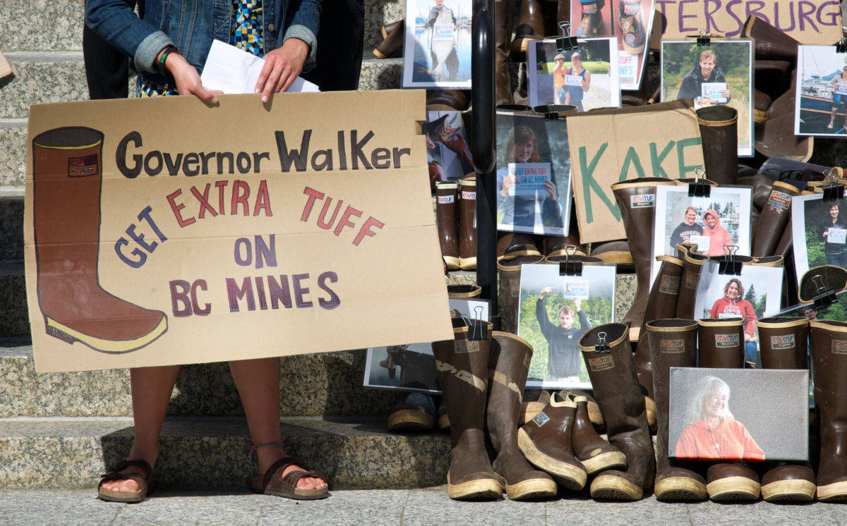 In this file photo from 2015, a protester stands next to rubber boots on the steps of the Alaska State Capitol during a rally to bring attention to the long-term protection of transboundary waters, principally the Taku, Stikine and Unuk watersheds. (Michael Penn | Juneau Empire)