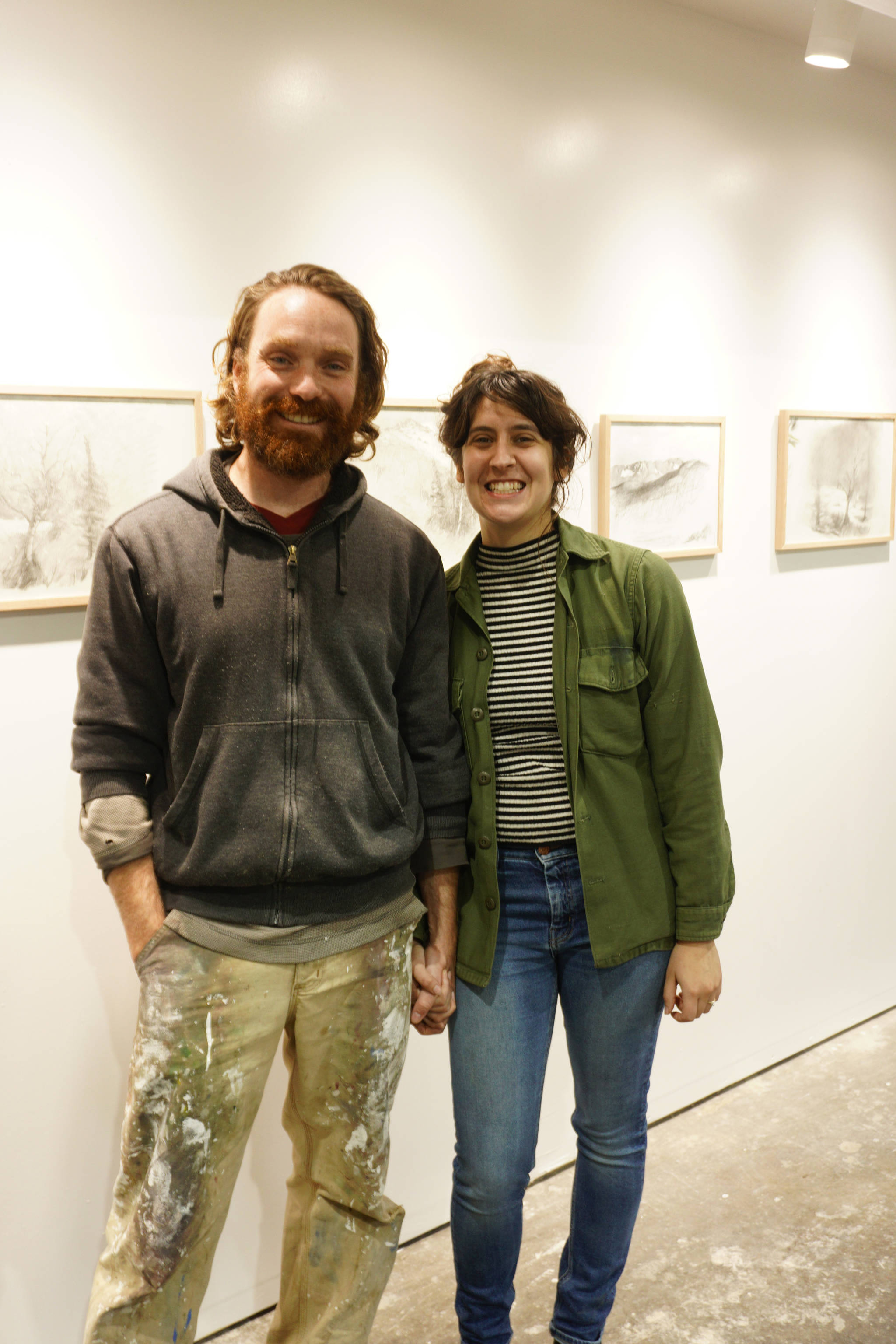 David and Elissa Pettibone pose on Tuesday, Oct. 16, 2018, by an exhibit of Karl Koett’s work at The Shop, an art space the Pettibones started in August 2018 in Kachemak City, Alaska. The Shop includes gallery space, but provides studio and classroom space as its main focus. (Photo by Michael Armstrong/Homer News)