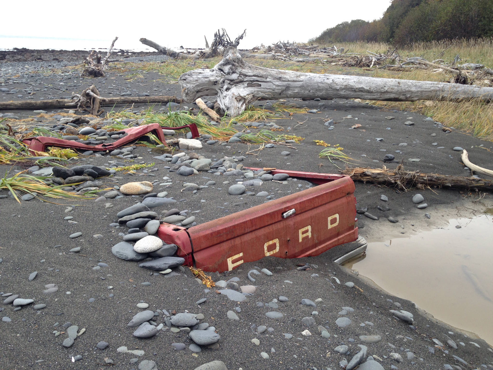 Storm tides have almost totally buried a Ford F-150 pickup truck on the beach south of Diamond Creek in this photo taken on Sunday, Oct. 14, 2018, near Homer, Alaska. The truck was abandoned on the beach in October 2011 and had then been on its tires. (Photo by Michael Armstrong/Homer News)