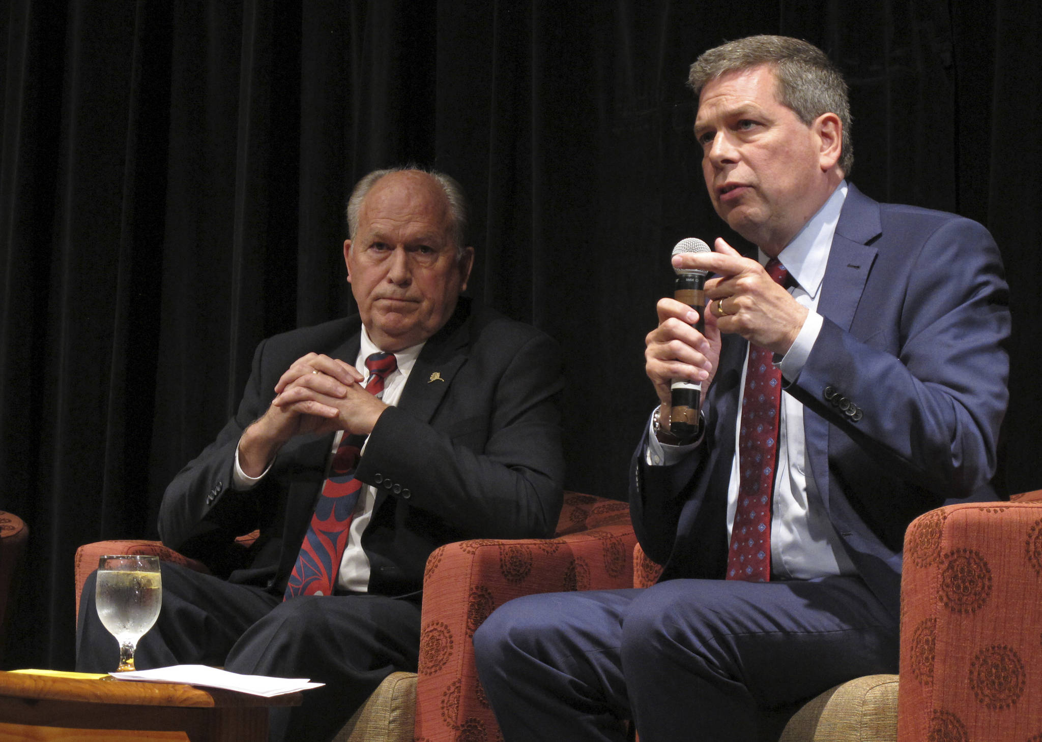Democratic nominee for governor in Alaska, Mark Begich, speaks during a chamber of commerce gubernatorial candidate forum on Thursday, Sept. 6, 2018, in Juneau, Alaska, as Gov. Bill Walker, left, looks on. The forum featured the three major candidates in the race, including Republican nominee Mike Dunleavy, who is not pictured. (AP Photo/Becky Bohrer)