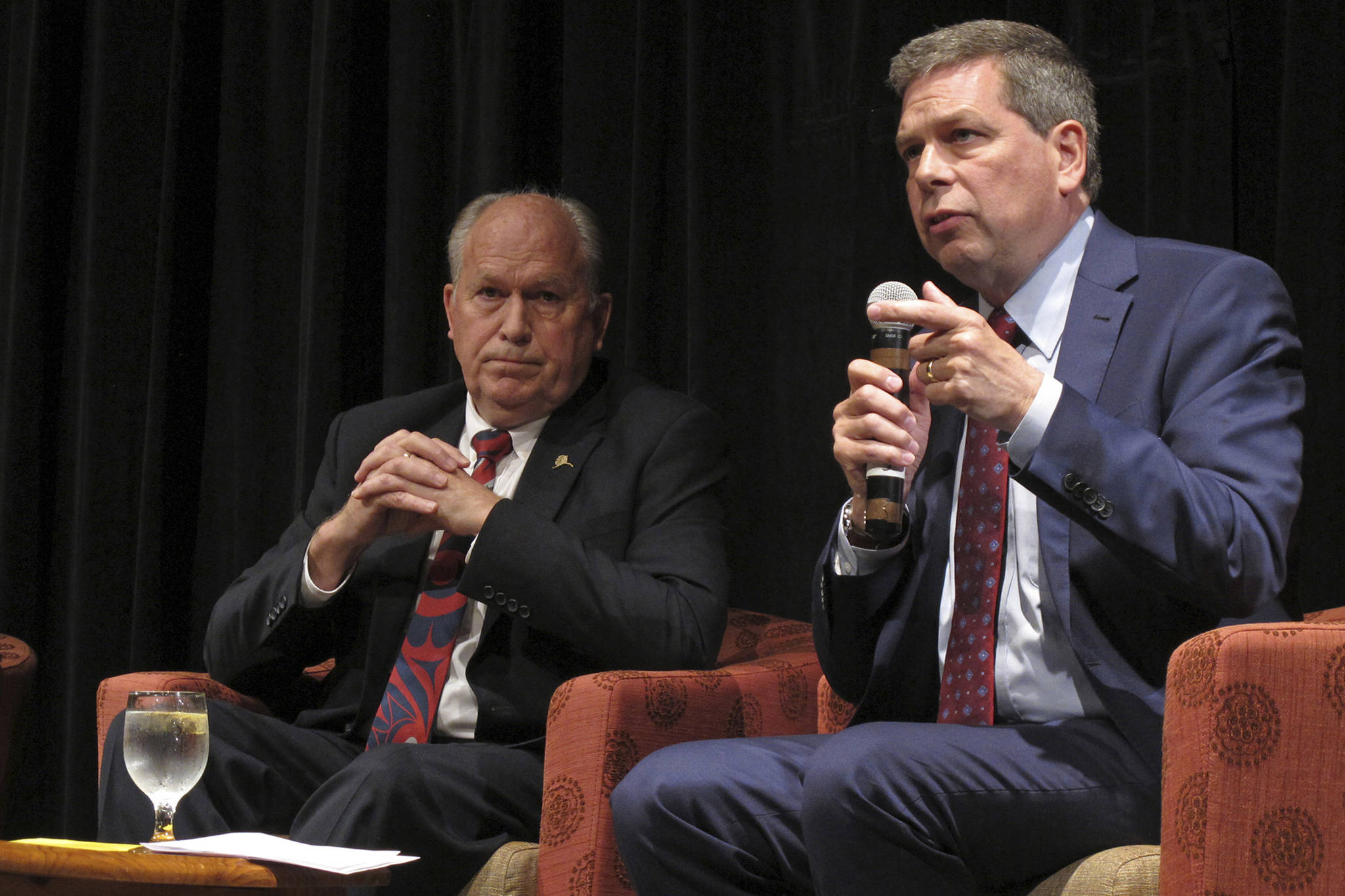 In this Sept. 6 file photo, Democratic nominee for governor of Alaska Mark Begich, right, speaks as Gov. Bill Walker listens during a chamber of commerce gubernatorial candidate forum on Thursday, Sept. 6, 2018, in Juneau, Alaska, On Friday, Oct. 19, Walker announced he was dropping his bid for re-election, though his name remains on the ballot. He threw his support behind Begich, who will face Republican Mike Dunleavy in November. (AP Photo/Becky Bohrer, File)
