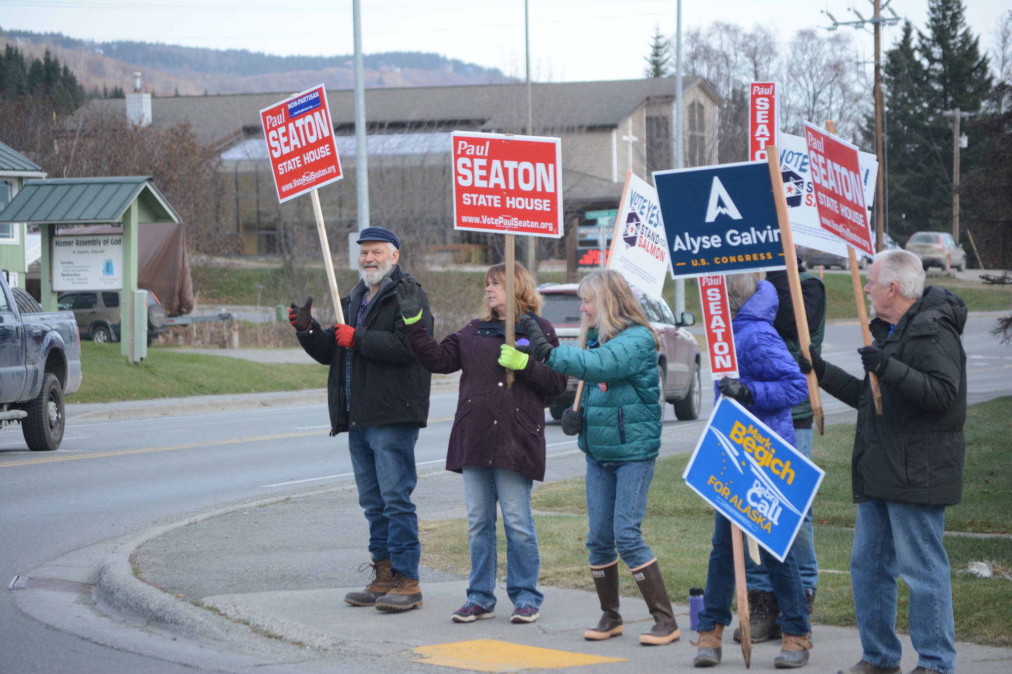 Rep. Paul Seaton, left, waves signs with other supports at the corner of Lake Street and East End Road on Nov. 6, 2018, in Homer, Alaska. (Photo by Michael Armstrong/Homer News)