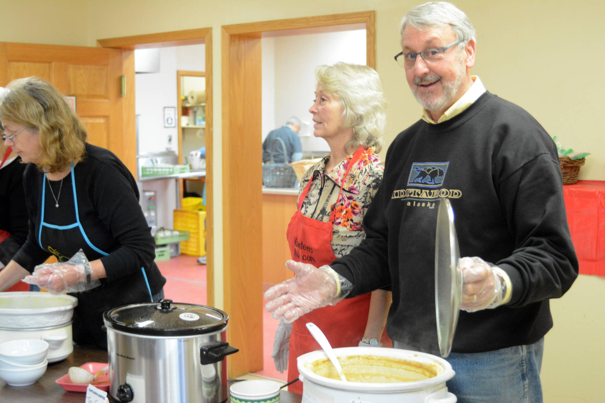 Dennis Weidler, coordinator of the Homer Community Food Pantry, right, serves soup at the Empty Bowls lunch Friday, Nov. 9, 2018, at Homer United Methodist Church in Homer, Alaska. Helping him are Deb Schmidt, center, and Karen Murdock, far left. More than 15 potters donated ceramic bowls for the annual fundraiser for the food pantry. (Photo by Michael Armstrong/Homer News)
