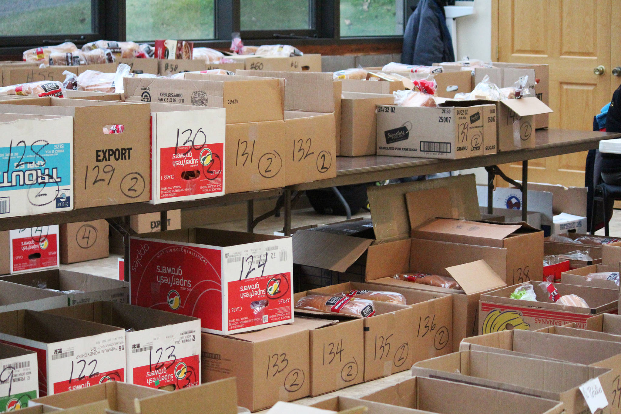 Boxes of food and ingredients are organized by the Kachemak Bay Lion’s Club for their annual Thanksgiving baskets Sautrday, Nov. 17, 2018 at the Homer United Methodist Church in Homer, Alaska. (Photo by Megan Pacer/Homer News)