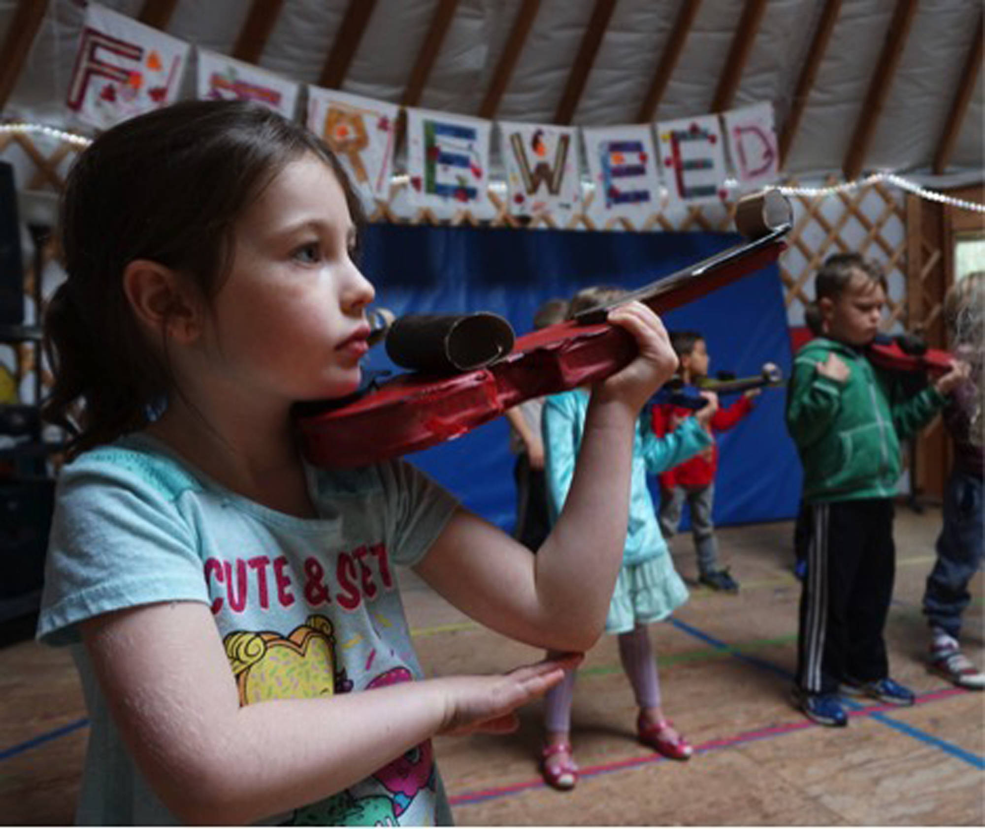 <span class="neFMT neFMT_PhotoCredit">Photo by Miranda Weiss</span>                                First grade student Elizabeth Parke practices holding a cardboard violin, in anticipation of the real thing, at Fireweed Academy in Homer.