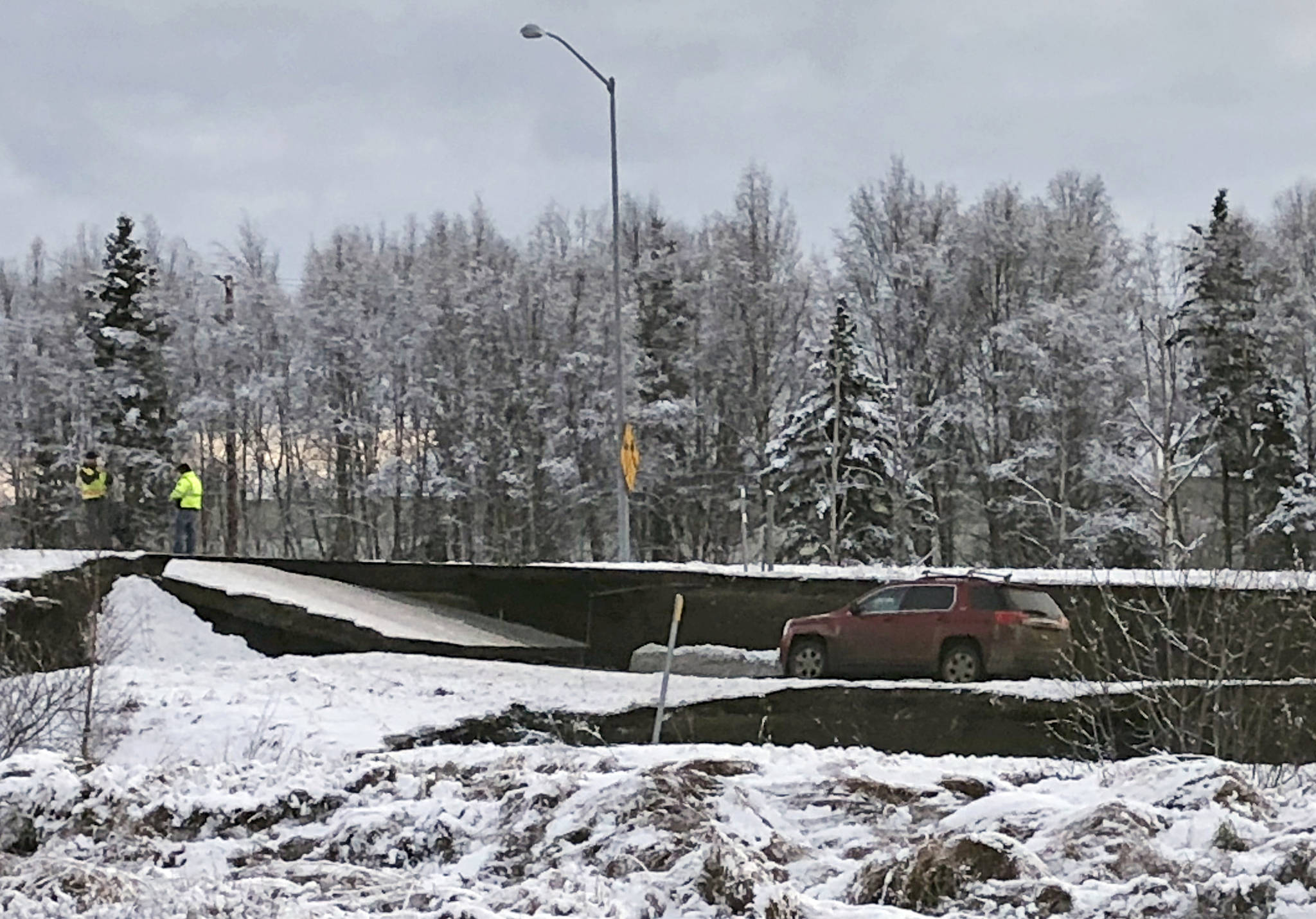 A car is trapped on a collapsed section of the offramp off of Minnesota Drive in Anchorage, Friday, Nov. 30, 2018. Back-to-back earthquakes measuring 7.0 and 5.8 rocked buildings and buckled roads Friday morning in Anchorage, prompting people to run from their offices or seek shelter under office desks, while a tsunami warning had some seeking higher ground. (AP Photo/Dan Joling)