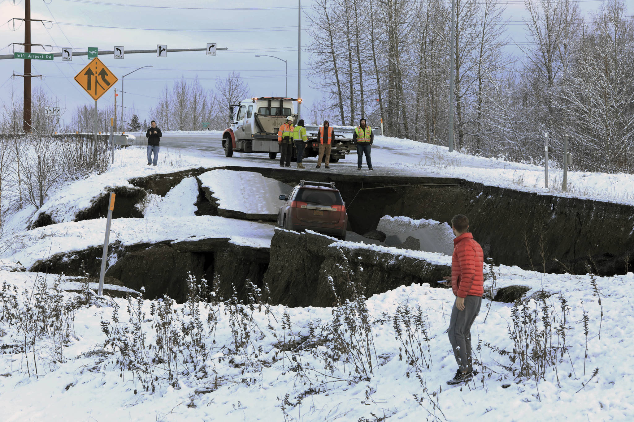 Highway workers and spectators look at a car stuck on a section of an off-ramp that collapsed during an earthquake Friday morning, Nov. 30, 2018 in Anchorage, Alaska. The driver was not injured attempting to exit Minnesota Drive at International Airport Road. Back-to-back earthquakes measuring 7.0 and 5.8 rocked buildings and buckled roads Friday morning in Anchorage, prompting people to run from their offices or seek shelter under office desks, while a tsunami warning had some seeking higher ground. (Dan Joling | Associated Press)