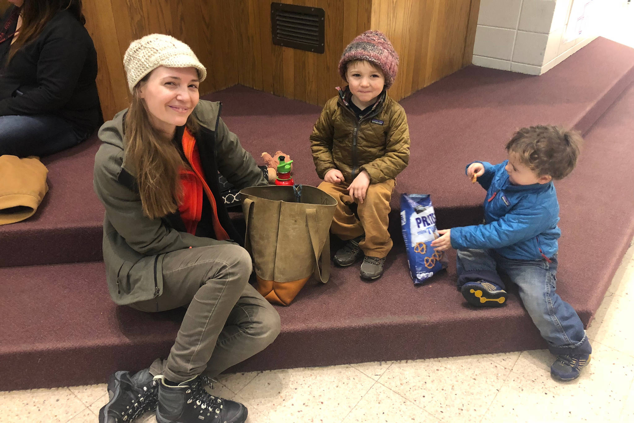 Katie Bower sits with her two children, Frederick and Lawrence, at the Homer High School, which was opened as a shelter after a 7 magnitude earthquake Friday, Nov. 30, 2018 in Homer, Alaska. A tsunami warning was issued for the Southern Kenai Peninsula but was lifted shortly after. (Photo by Renee Gross, KBBI)