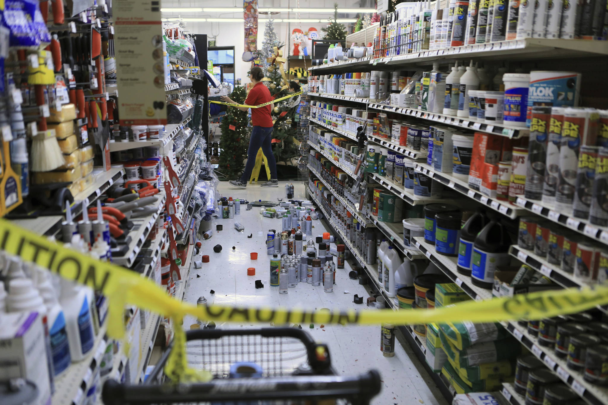 An employee walks past a damaged aisle at Anchorage True Value hardware store after an earthquake, Friday morning, Nov. 30, 2018, in Anchorage, Alaska. Tim Craig, owner of the south Anchorage store, said no one was injured but hundreds of items hit the floor and two shelves collapsed in a stock room. (AP Photo/Dan Joling)