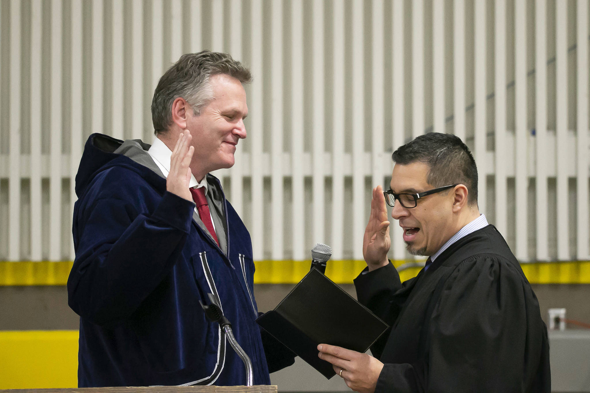 Mike Dunleavy, left, is sworn into office as Alaska’s governor by Superior Court Judge Paul Roetman in Kotzebue, Alaska, on Monday, Dec. 3, 2018. Poor visibility forced Dunleavey’s swearing-in ceremony to be held in Kotzebue instead of Noorvik, Alaska, his wife’s hometown. (Stanley Wright/Alaska Governor’s Office via AP)