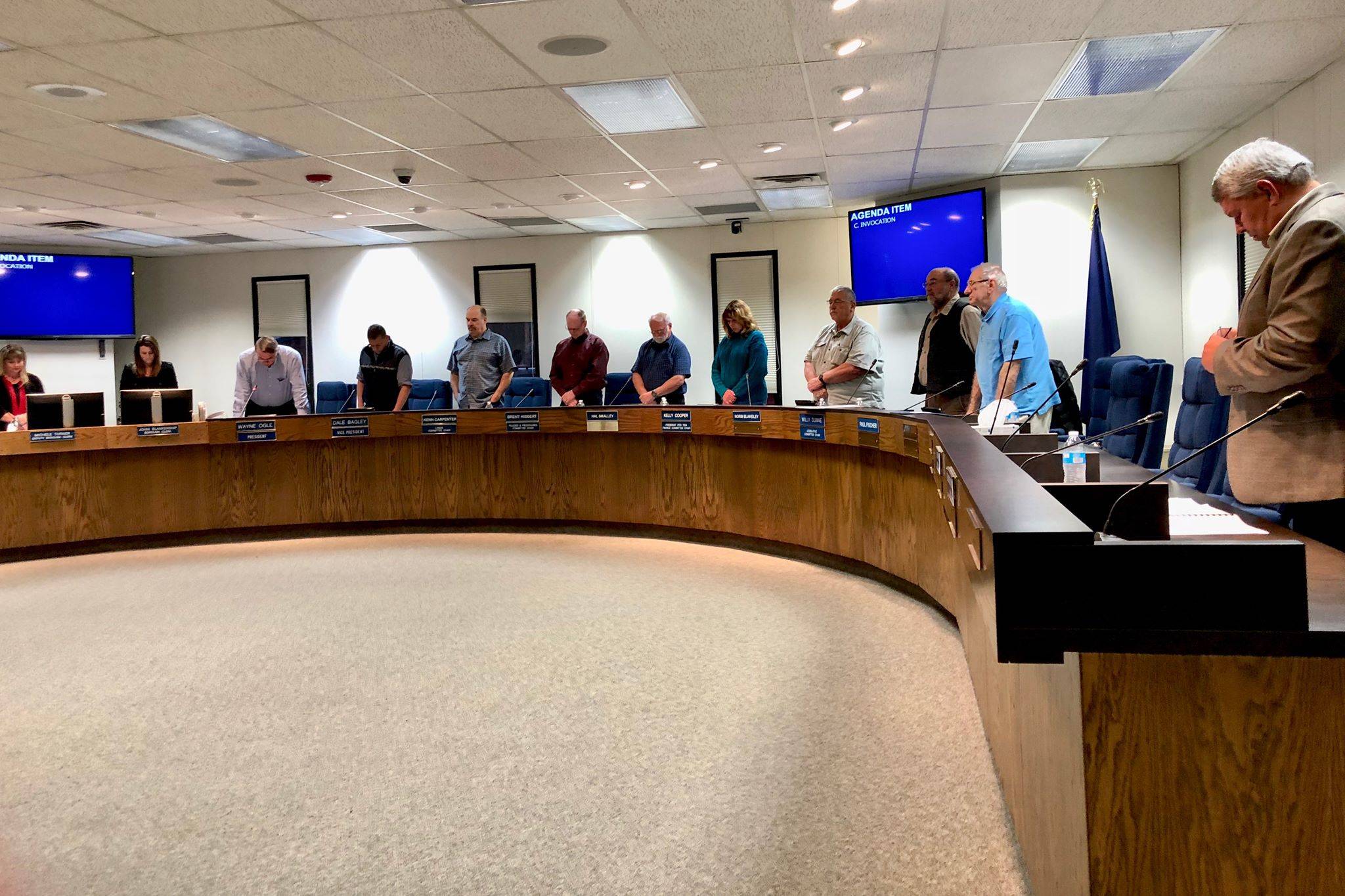 The Kenai Peninsula Borough Assembly stands in silence while Assembly President Wayne Ogle offers an invocation before the meeting, Tuesday, Oct. 23, 2018, in Soldotna, AK. (Photo by Victoria Petersen/Peninsula Clarion)