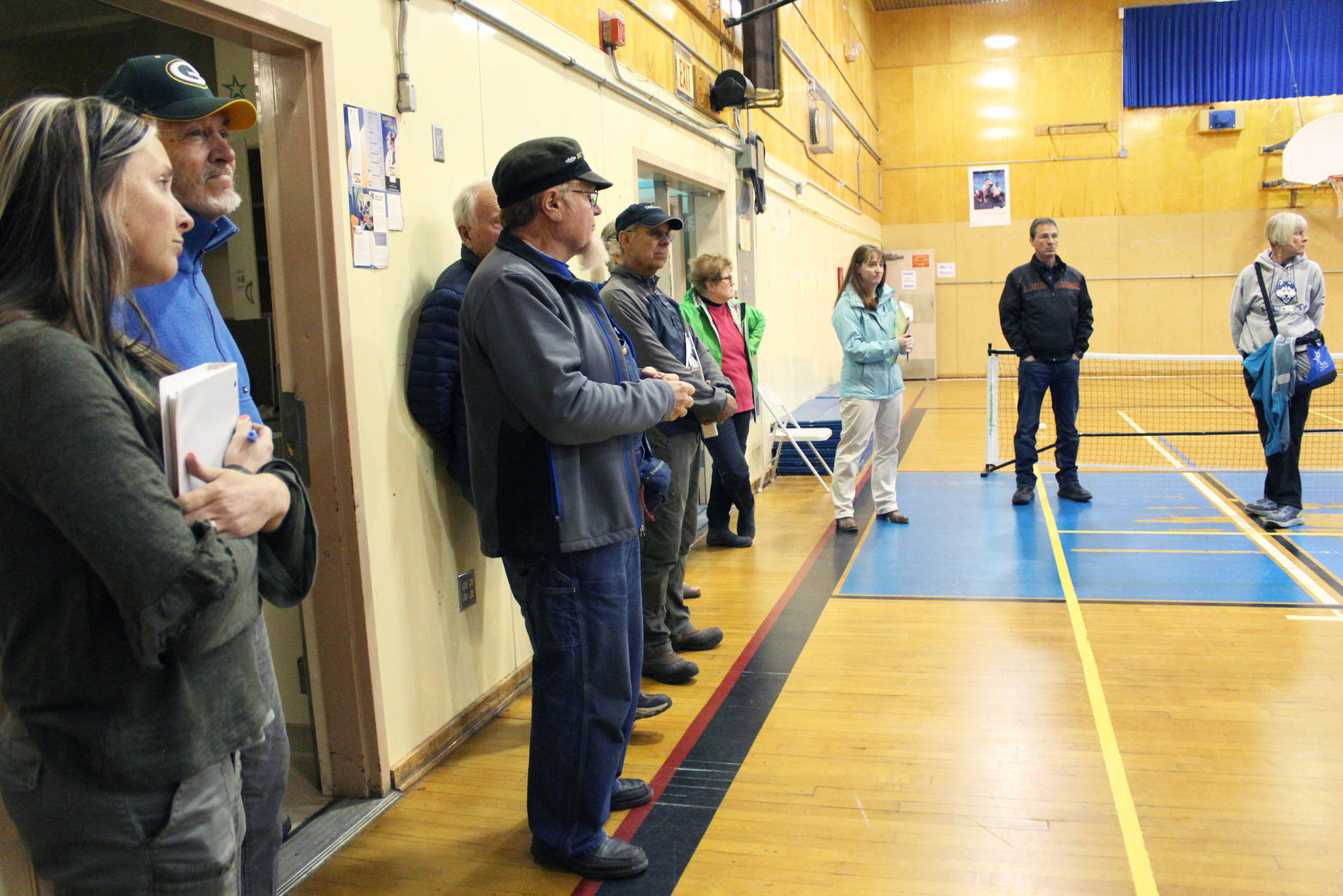 Members of the HERC Task Force and the public, located in the gym currently used for community recreation, listen to city staff talk about the state of the building during a walk-through Tuesday, June 26, 2018 in Homer, Alaska. (Photo by Megan Pacer/Homer News)
