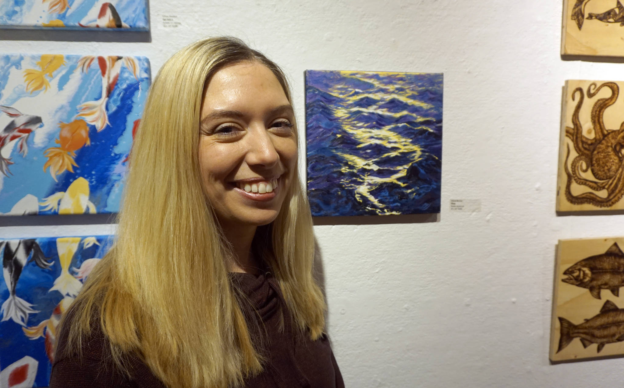 Maria Bernier stands by her painting, “Chop,” at the First Friday, Dec 7, 2018, opening of Bunnell Street Arts Center’s 10x10 show in Homer, Alaska. (Photo by Michael Armstrong/Homer News)