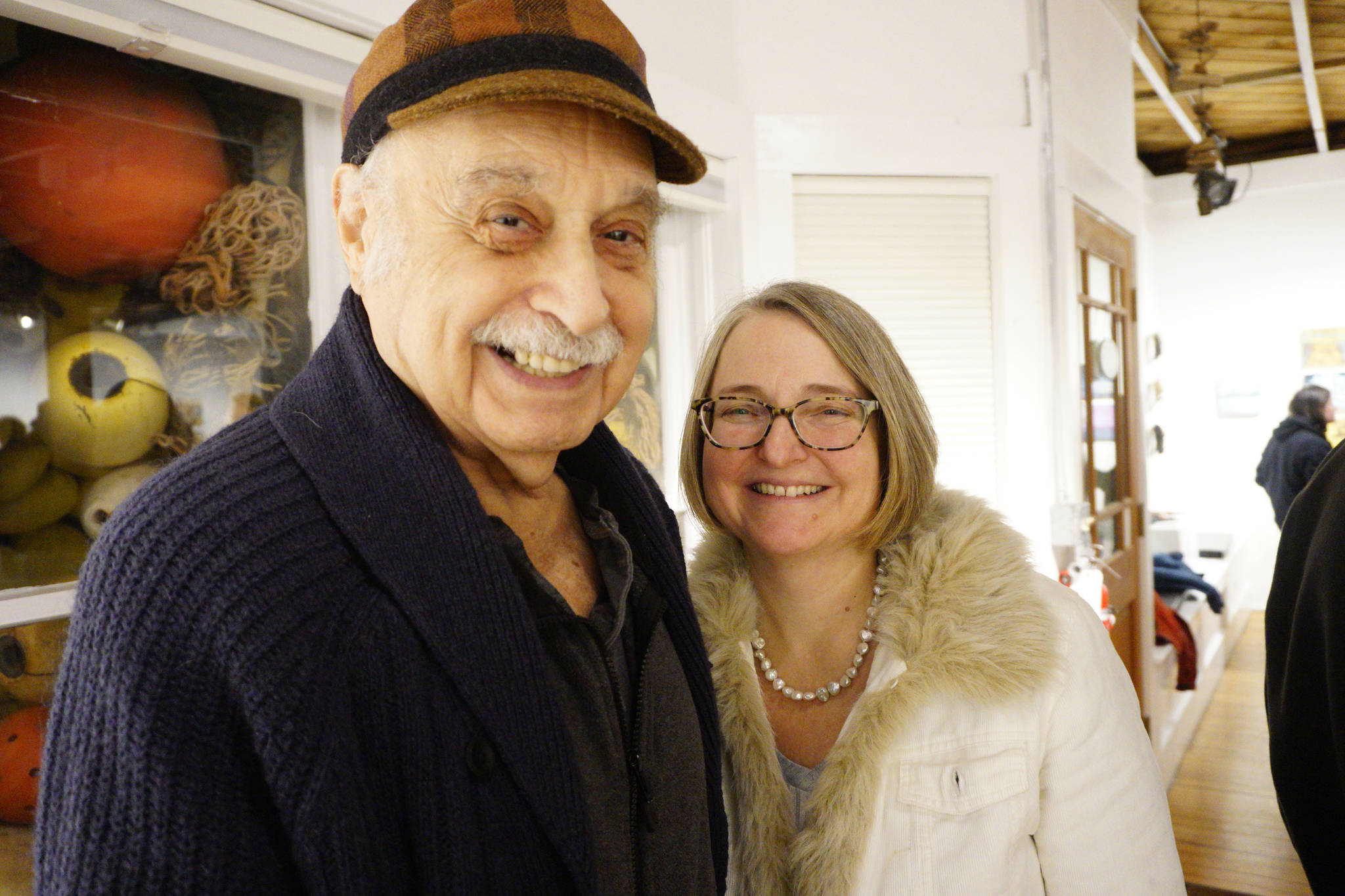 Jack Packer, left, and his daughter, Sharlene Cline, pose for a photo at the First Friday, Dec 7, 2018, opening of Bunnell Street Arts Center’s 10x10 show in Homer, Alaska. Both had paintings in the show. (Photo by Michael Armstrong/Homer News)
